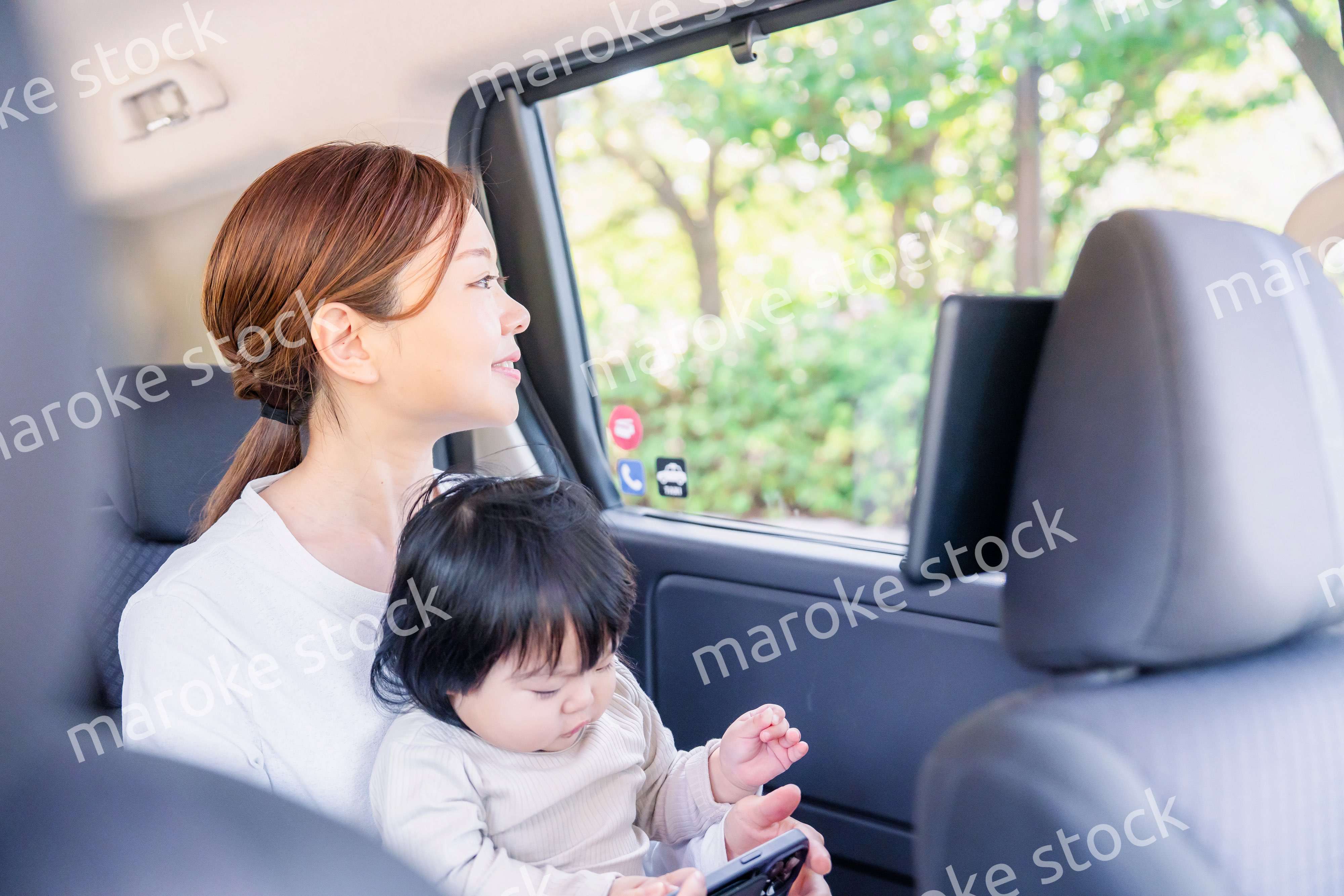 小さい子供と一緒にタクシーに乗るお母さん