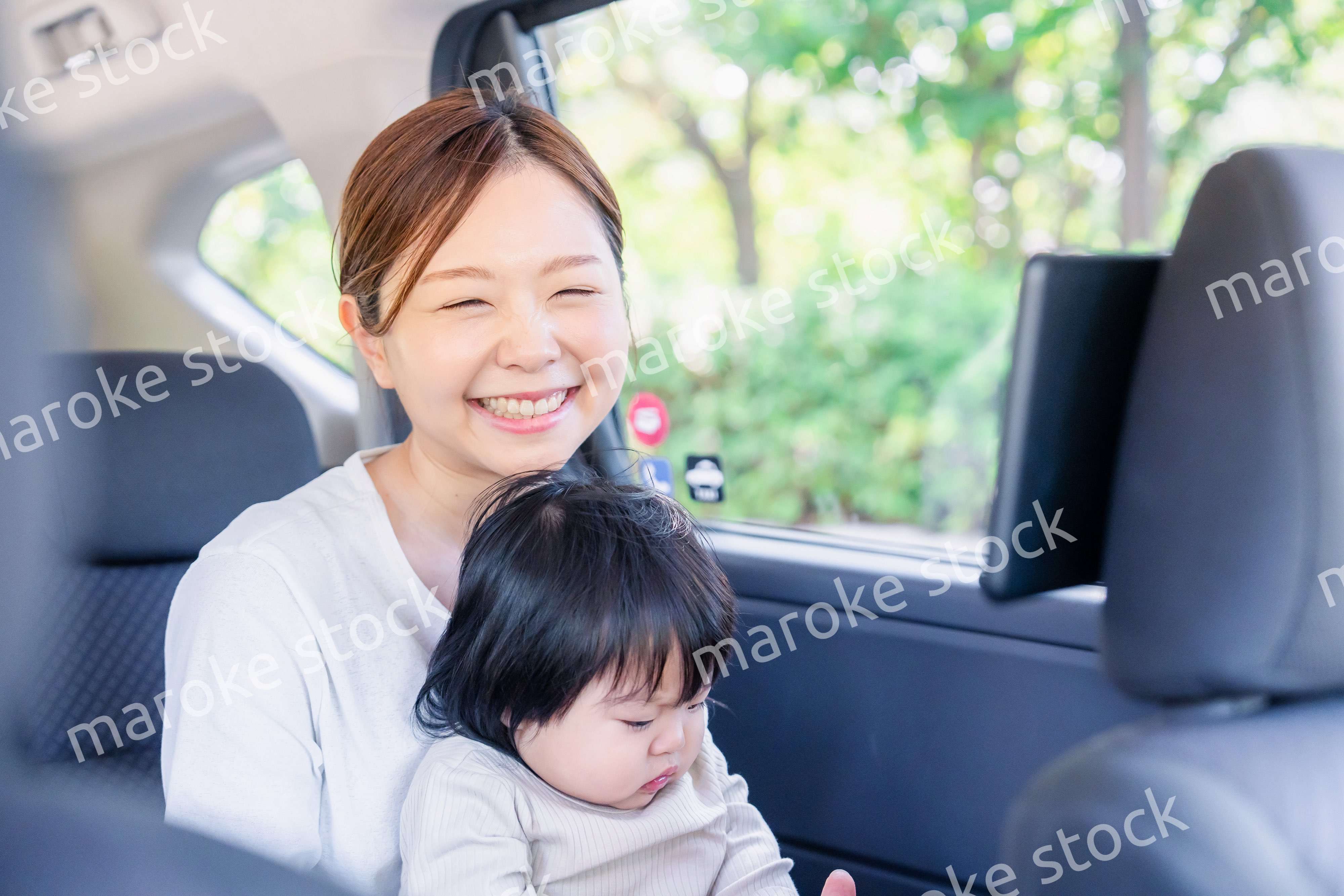 小さい子供と一緒にタクシーに乗るお母さん