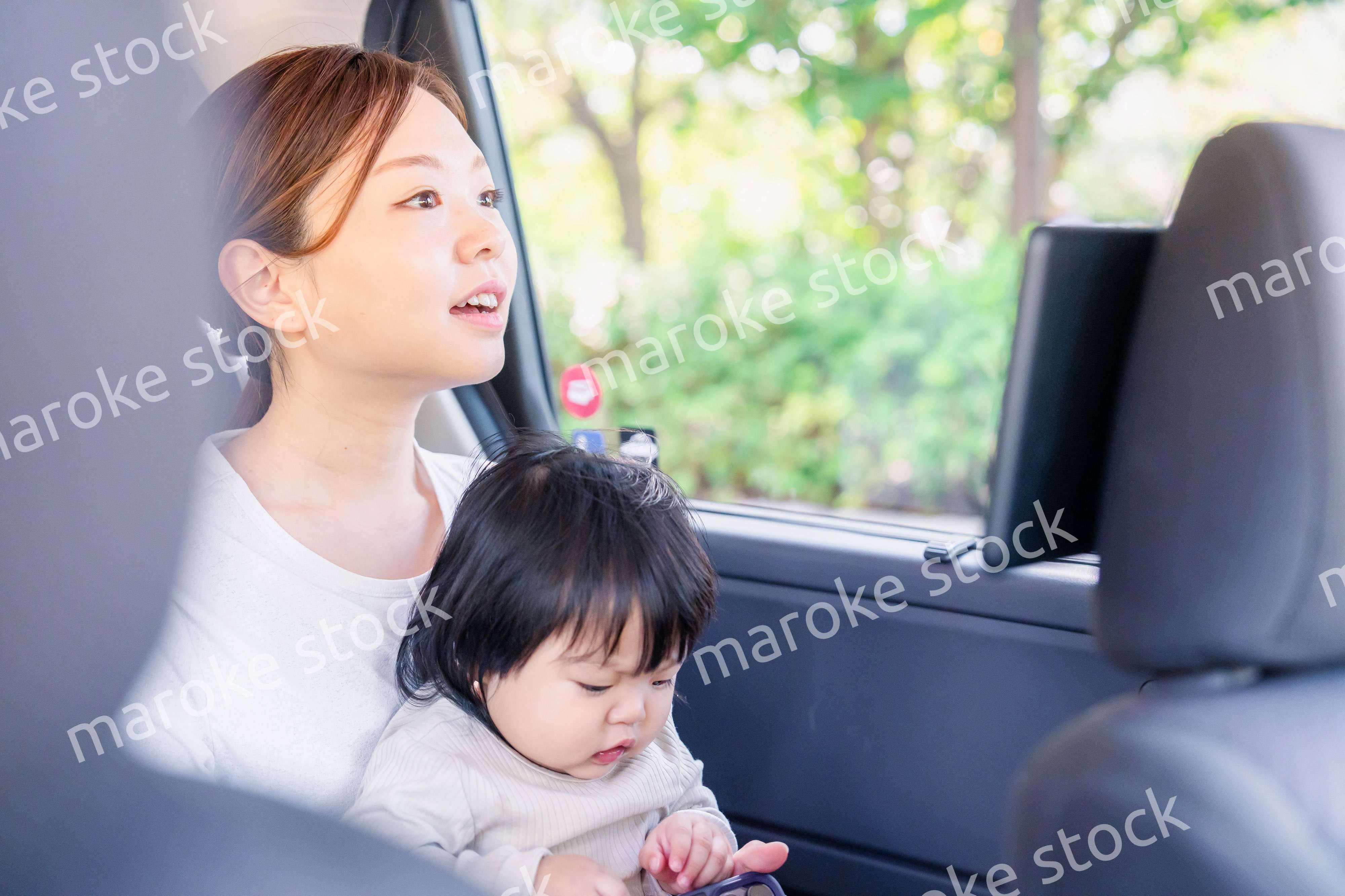 小さい子供と一緒にタクシーに乗るお母さん