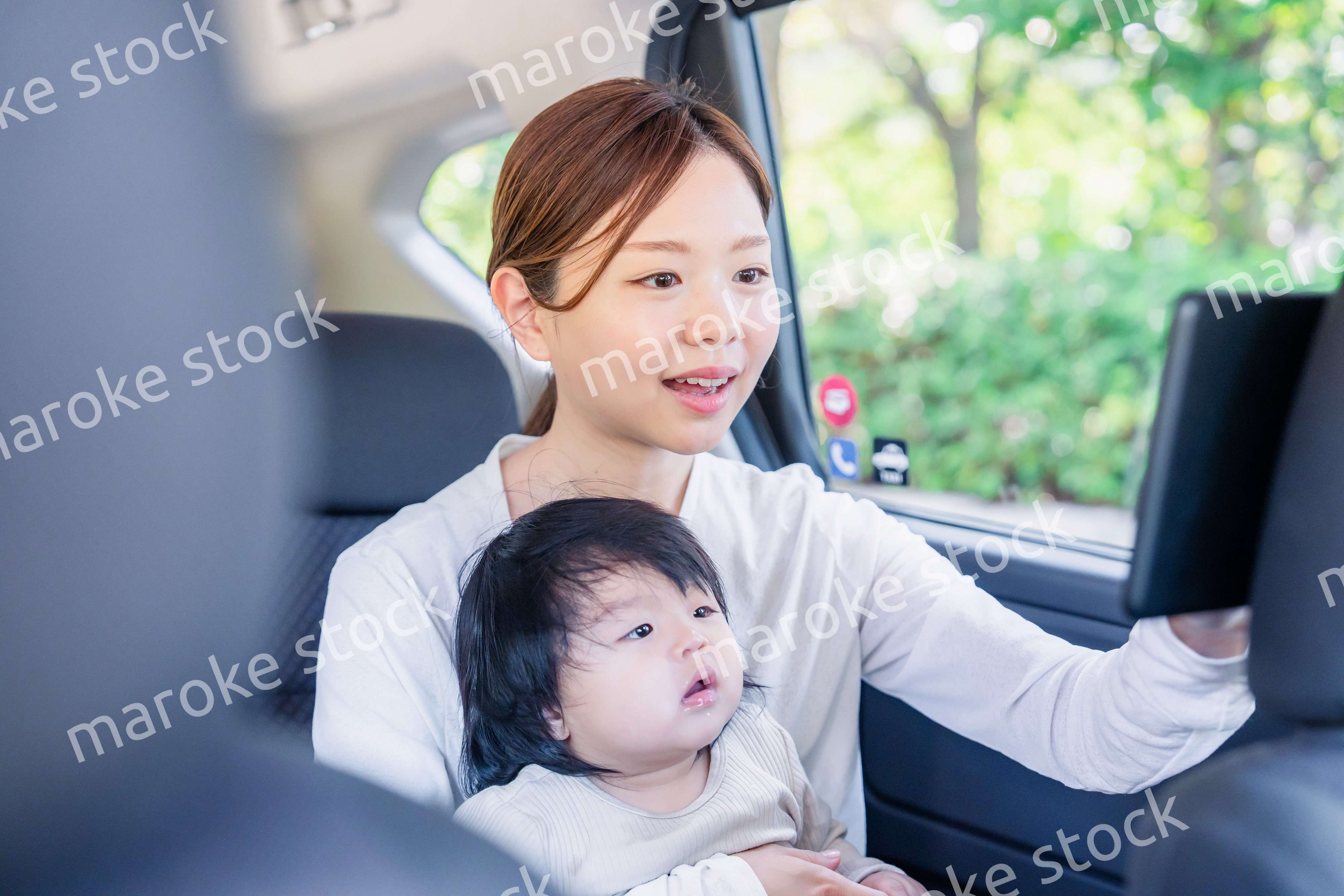 小さい子供と一緒にタクシーに乗るお母さん
