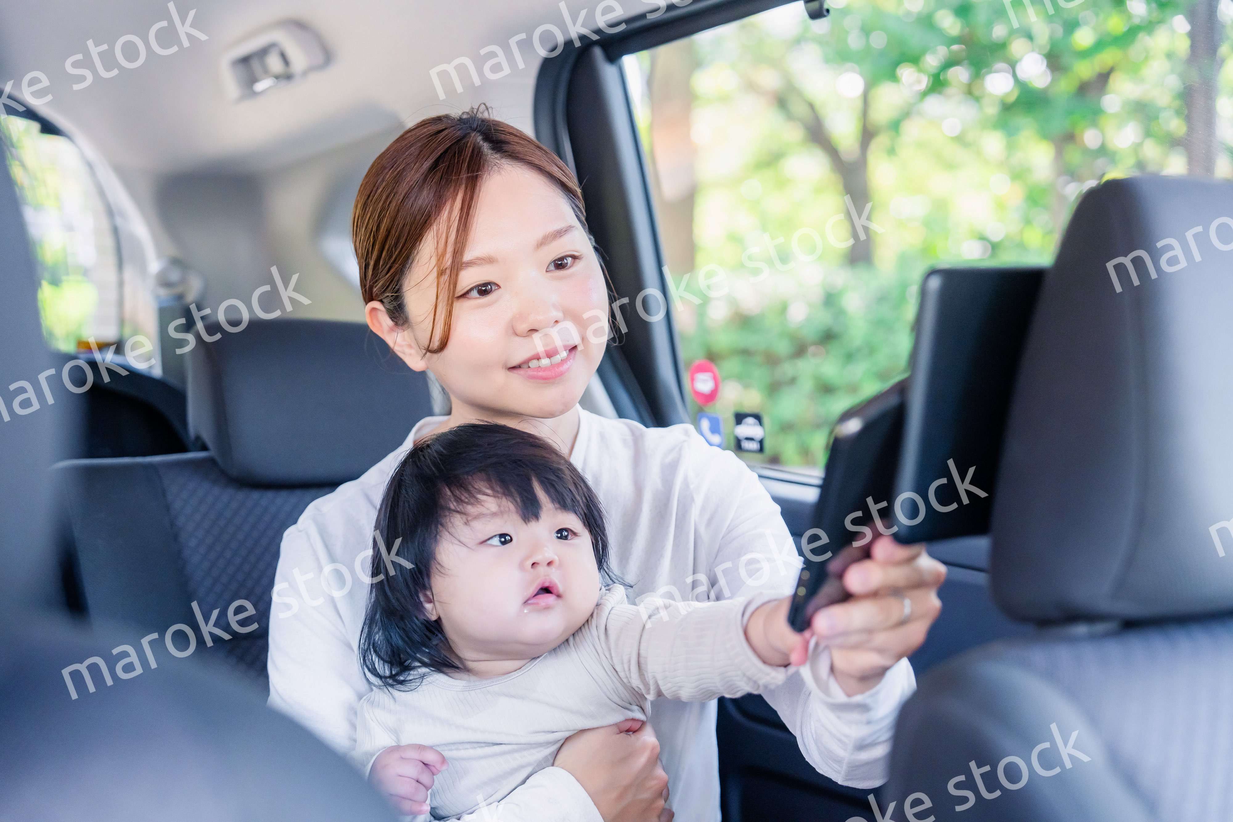 小さい子供と一緒にタクシーに乗るお母さん