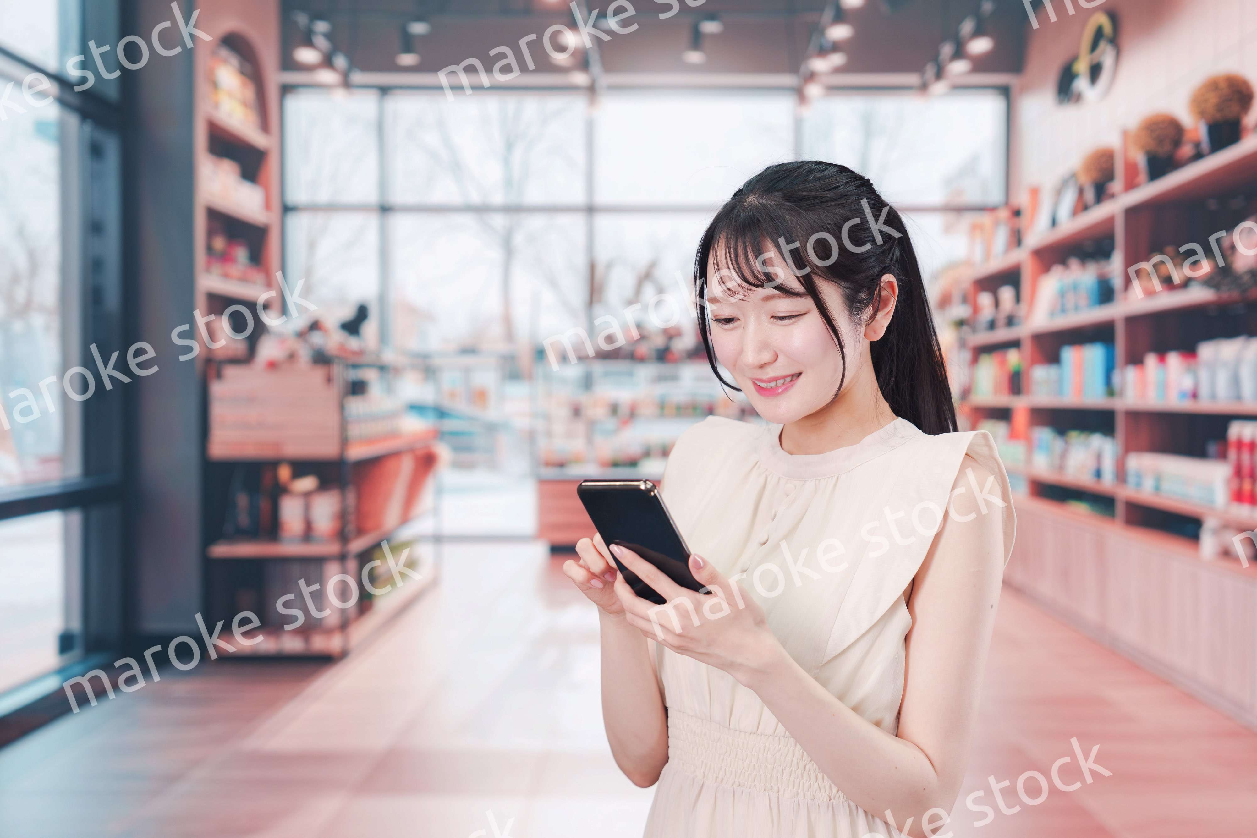 ショッピングをしながらスマホで検索をする若い女性