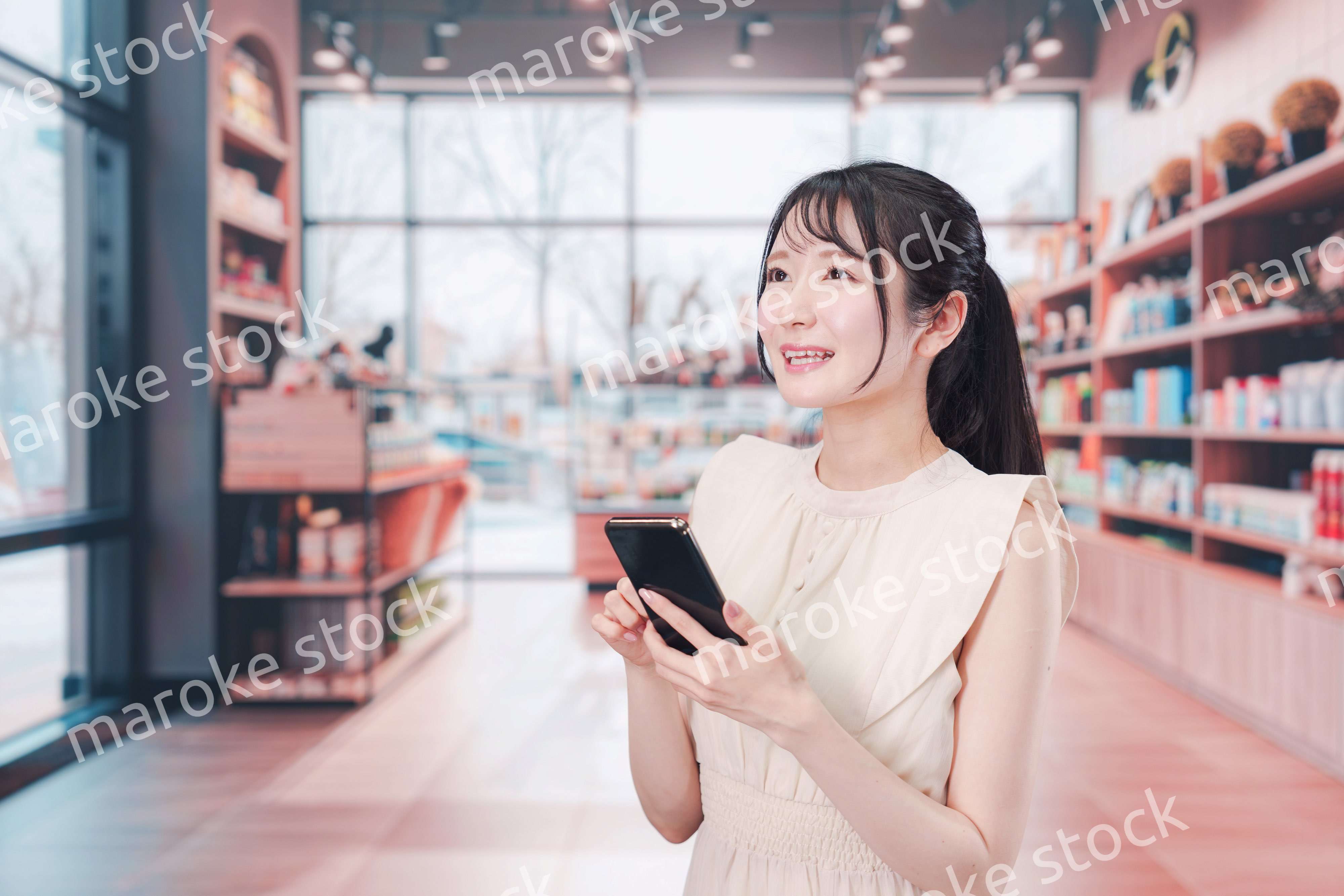 ショッピングをしながらスマホで検索をする若い女性