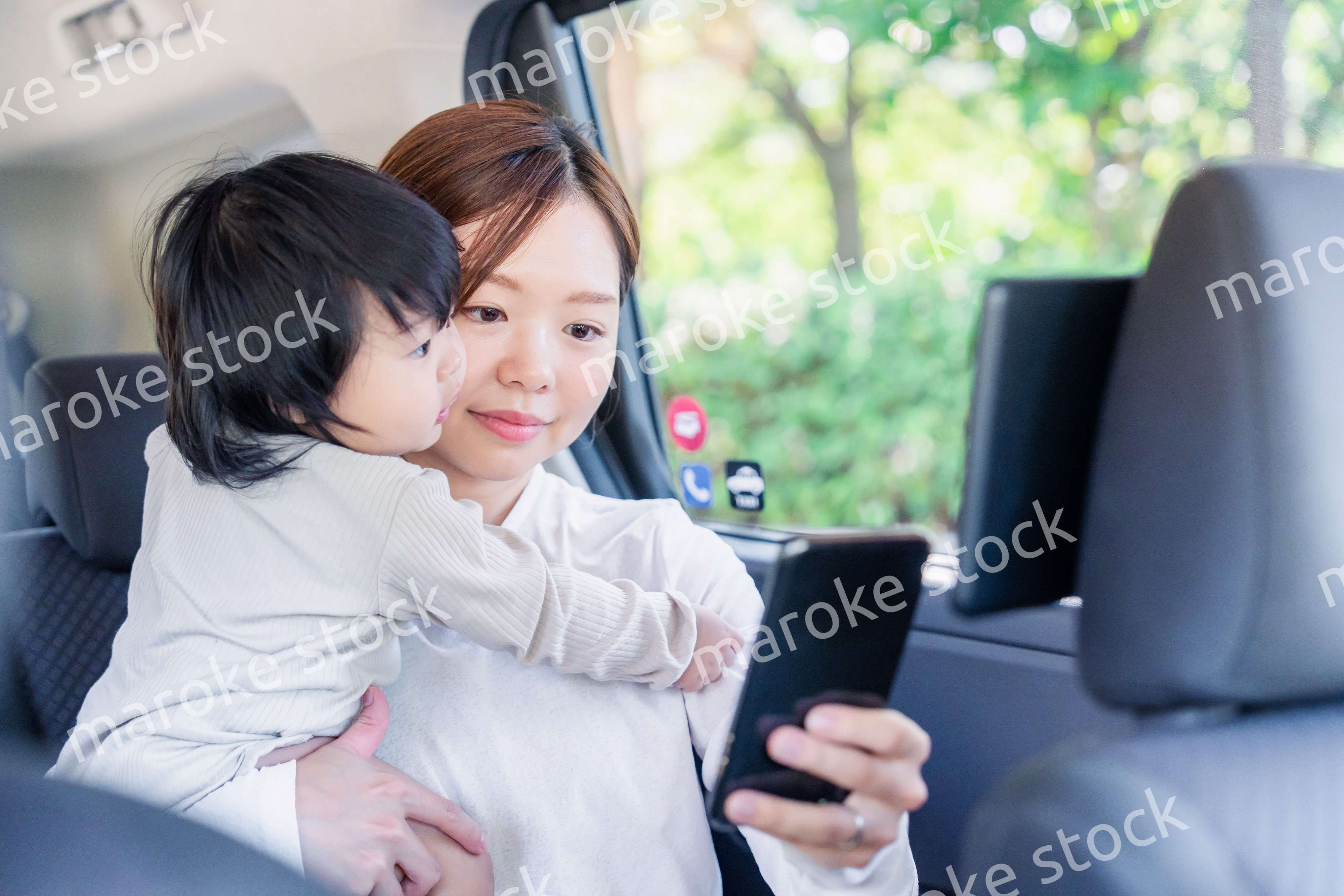 小さい子供と一緒にタクシーに乗るお母さん