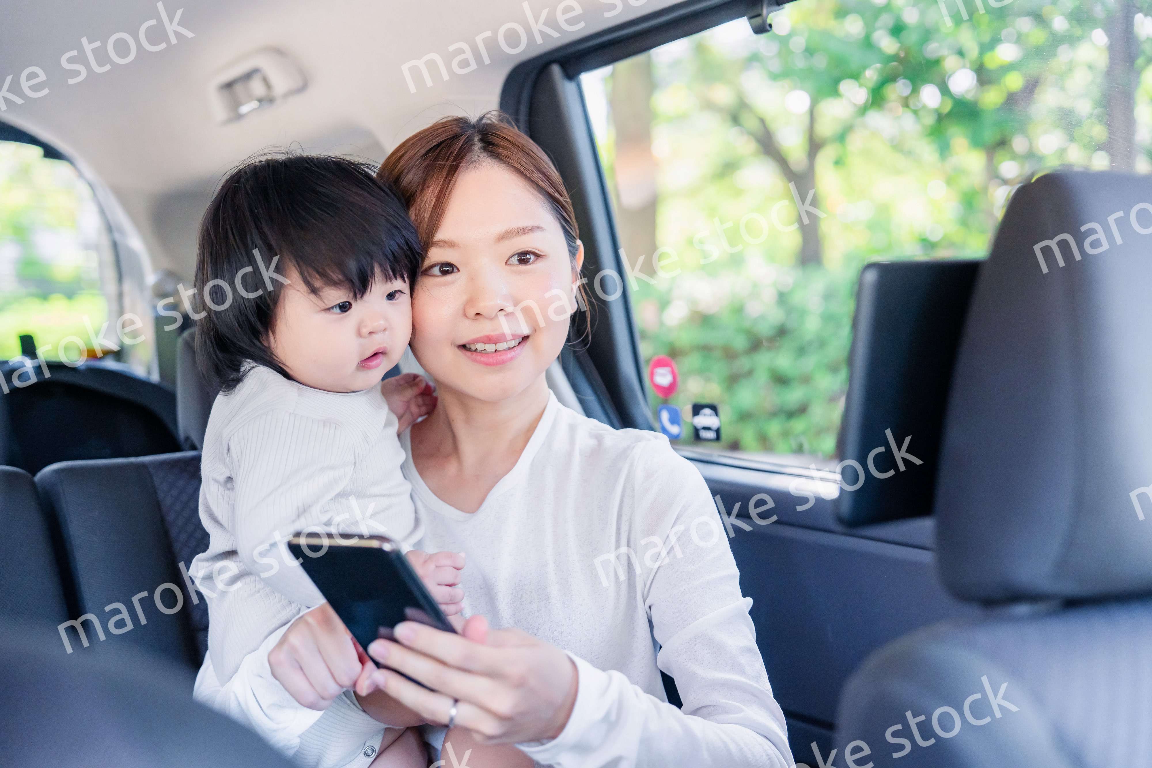 小さい子供と一緒にタクシーに乗るお母さん