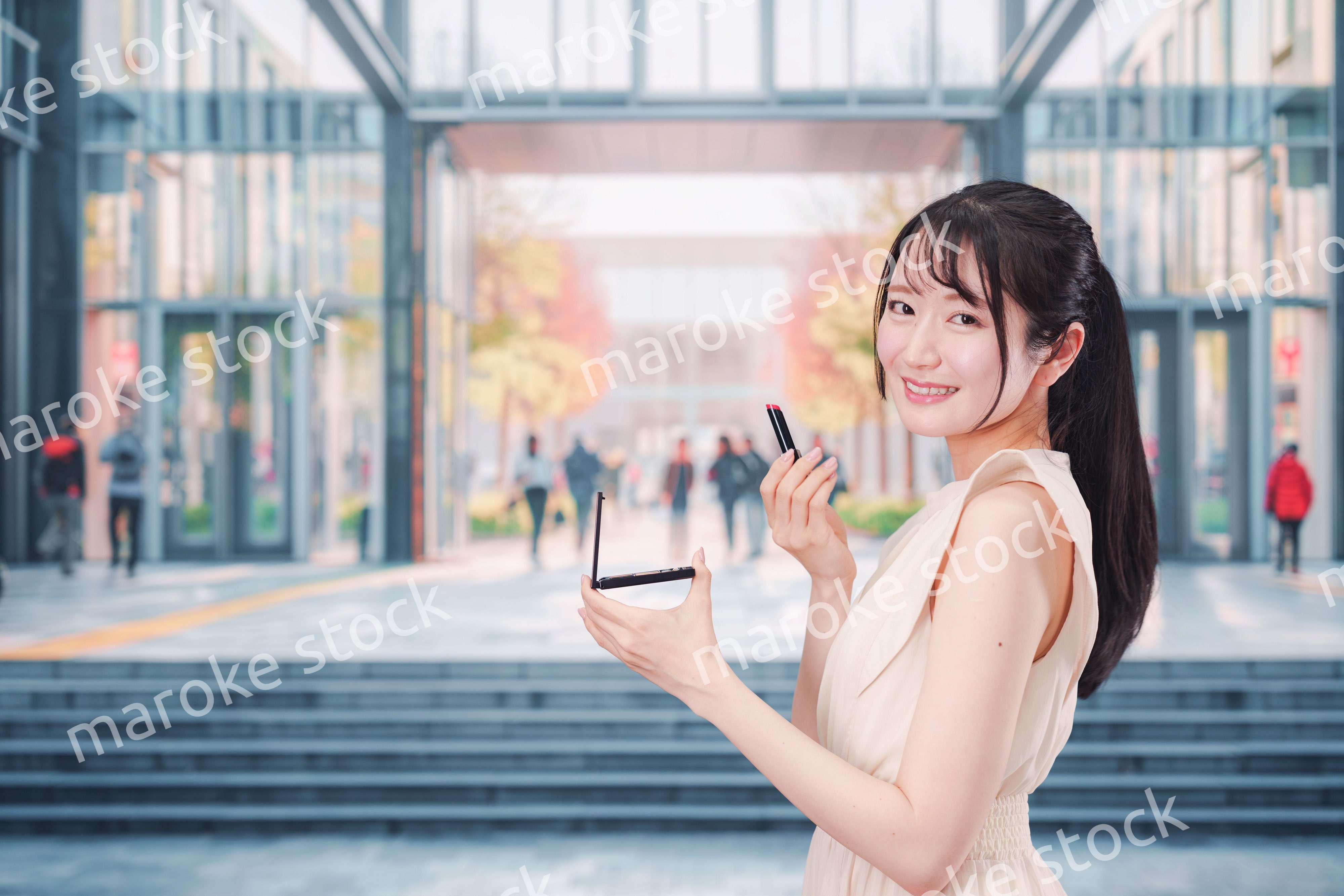 大学のキャンパスでお化粧をする大学生の女性