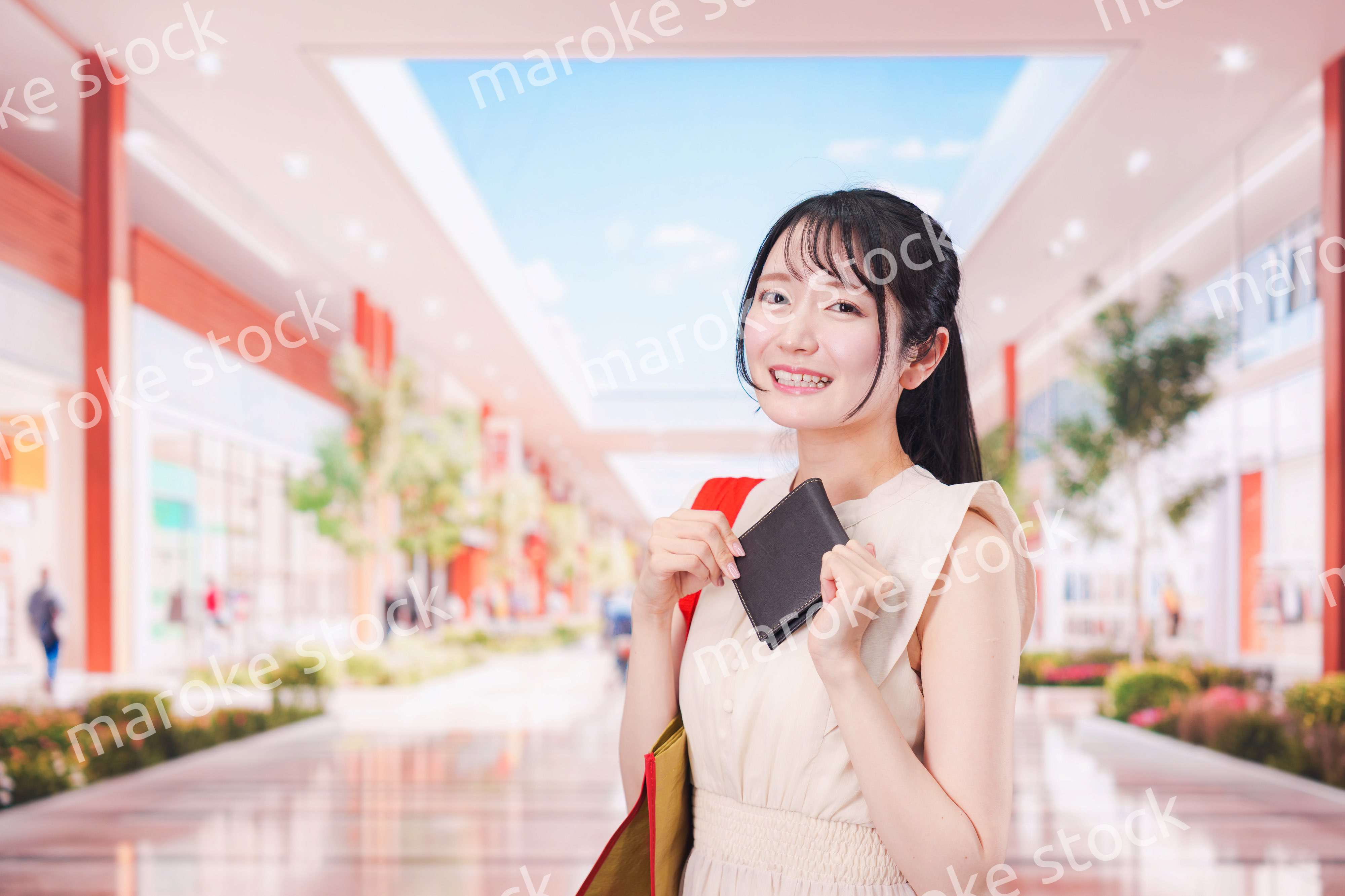 ショッピングモールで笑顔で買い物をする若い女性