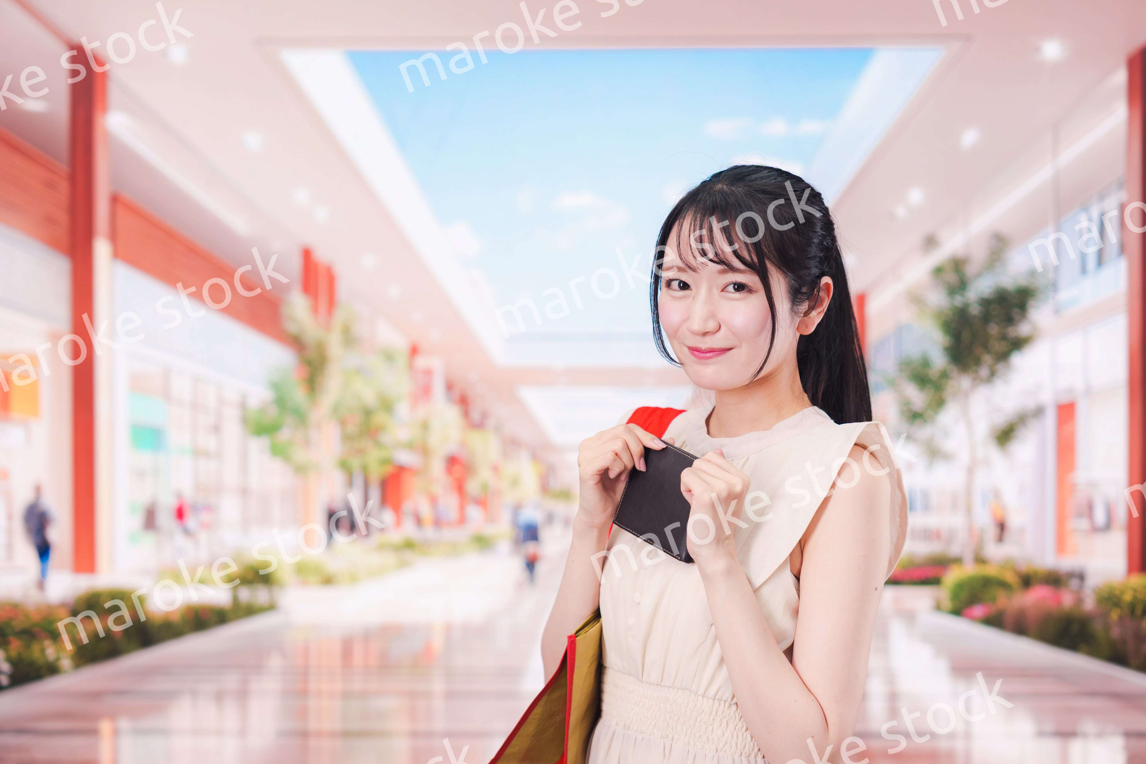 ショッピングモールで笑顔で買い物をする若い女性