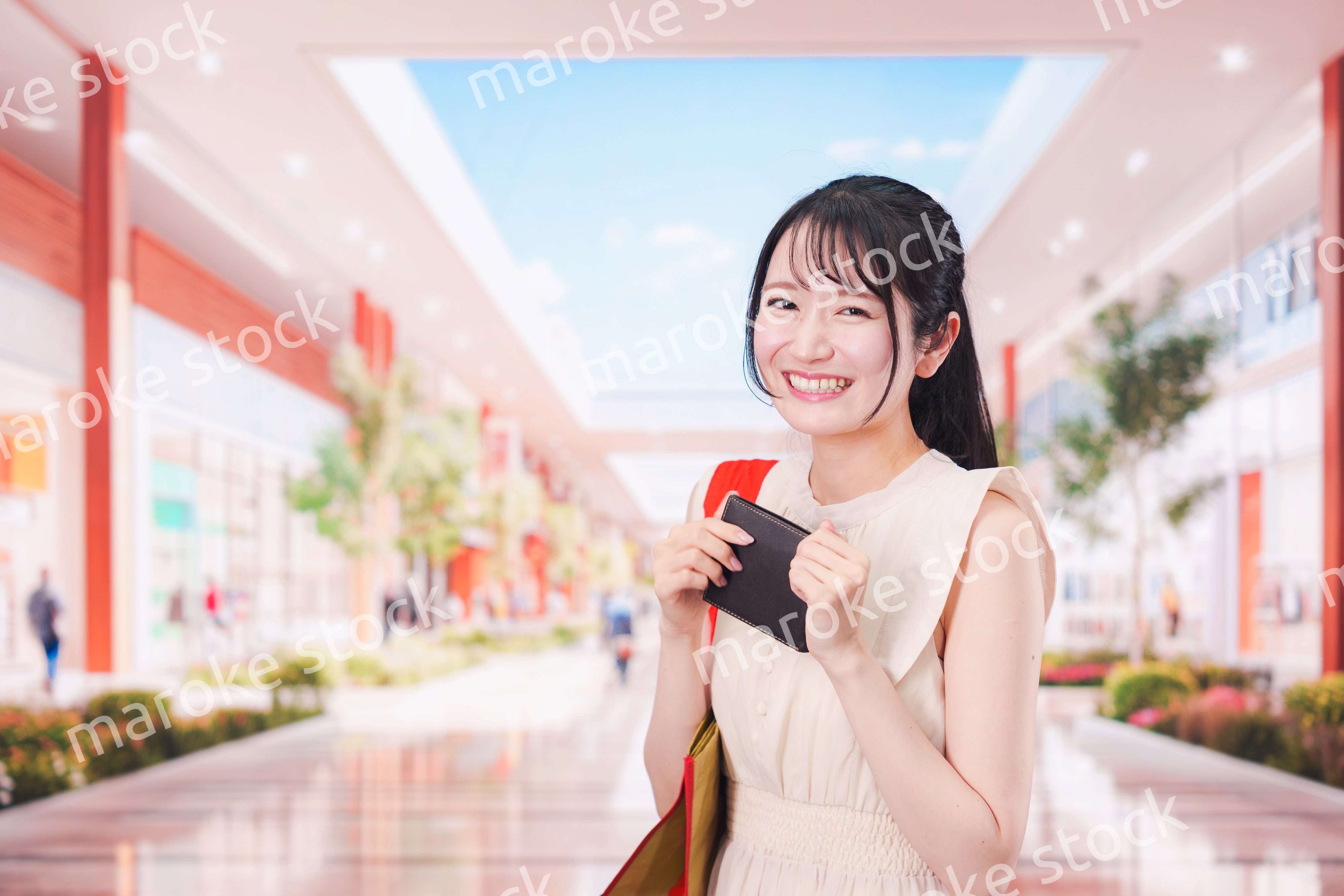 ショッピングモールで笑顔で買い物をする若い女性