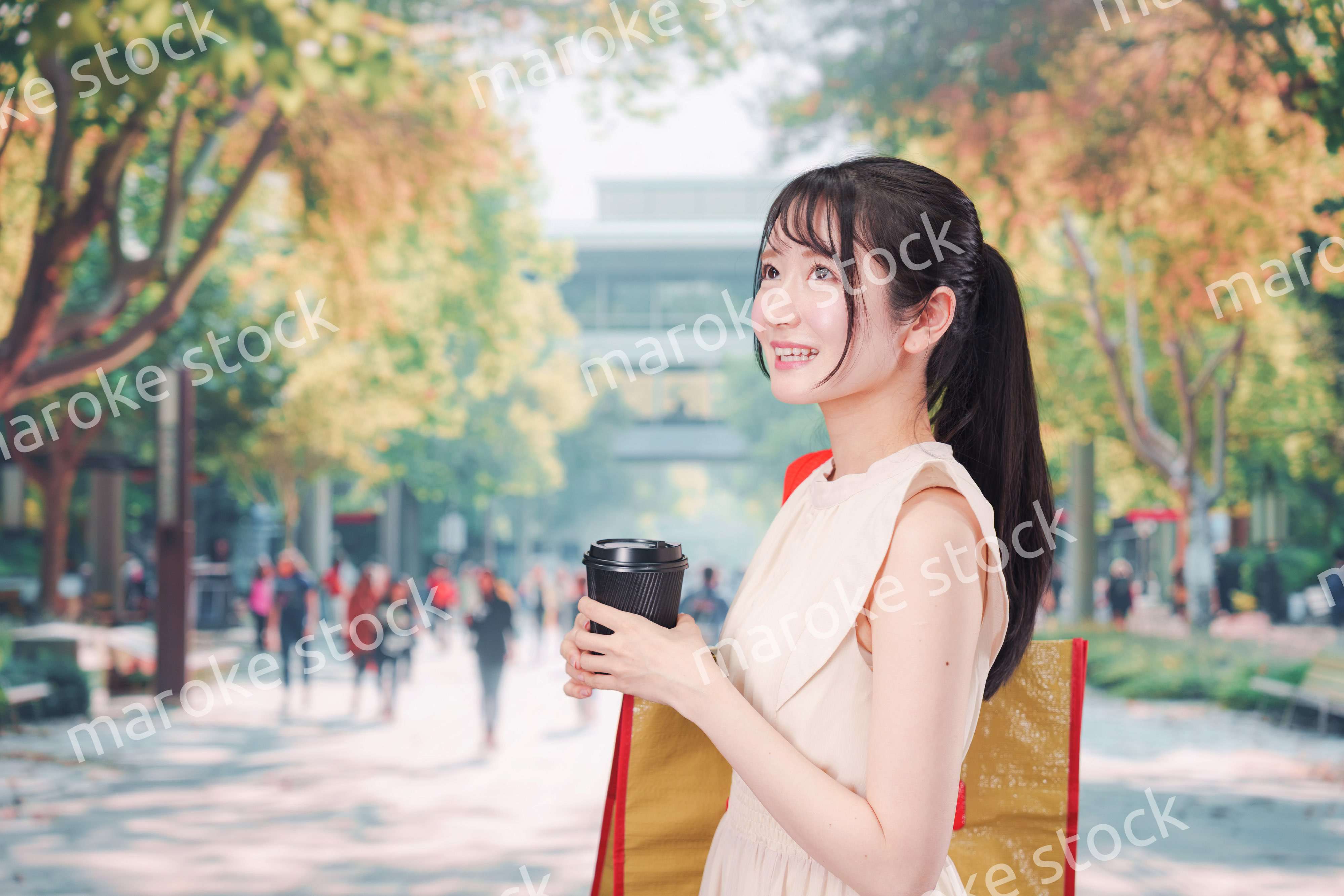 コーヒーを飲みながら外を歩く若い学生