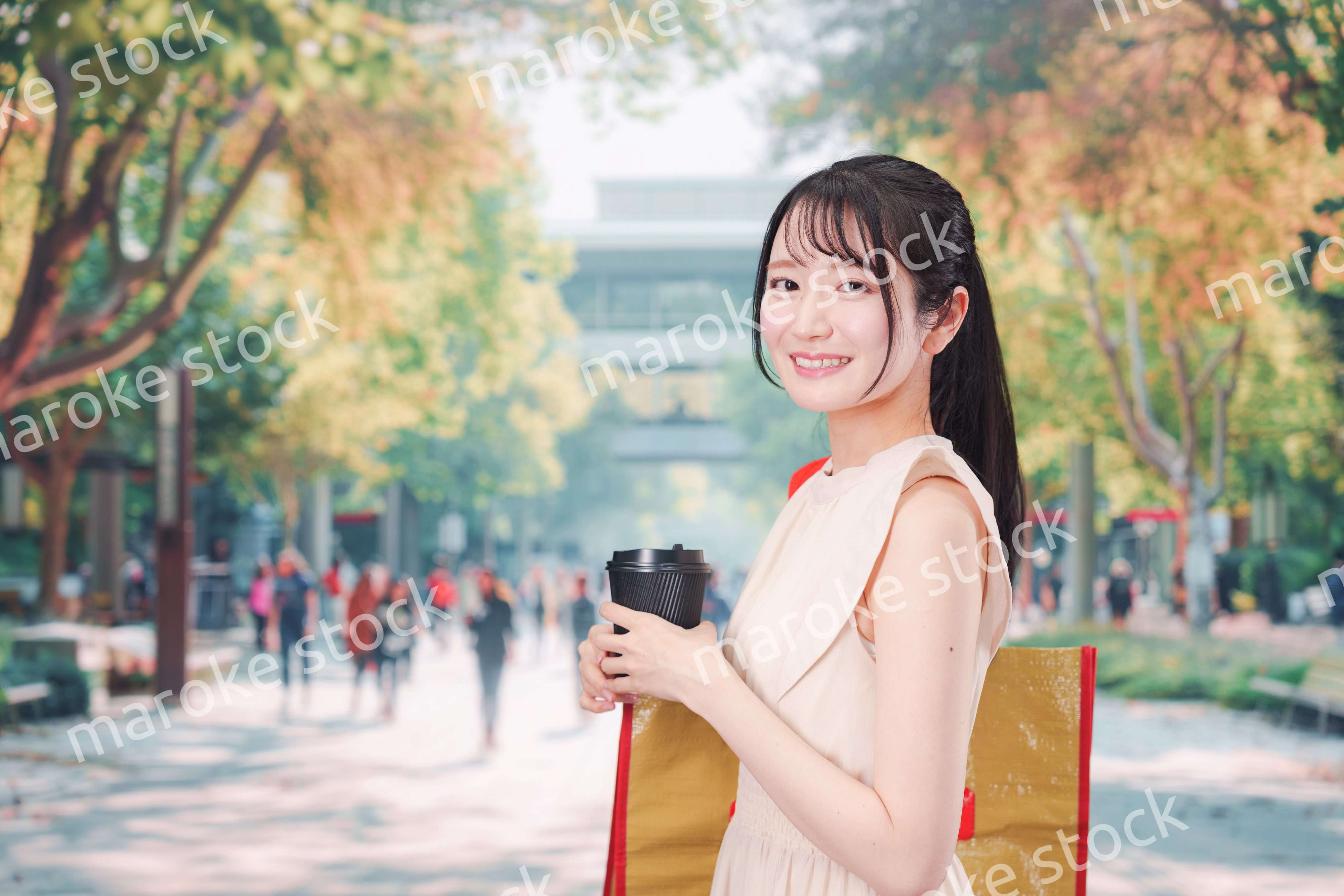 コーヒーを飲みながら外を歩く若い学生