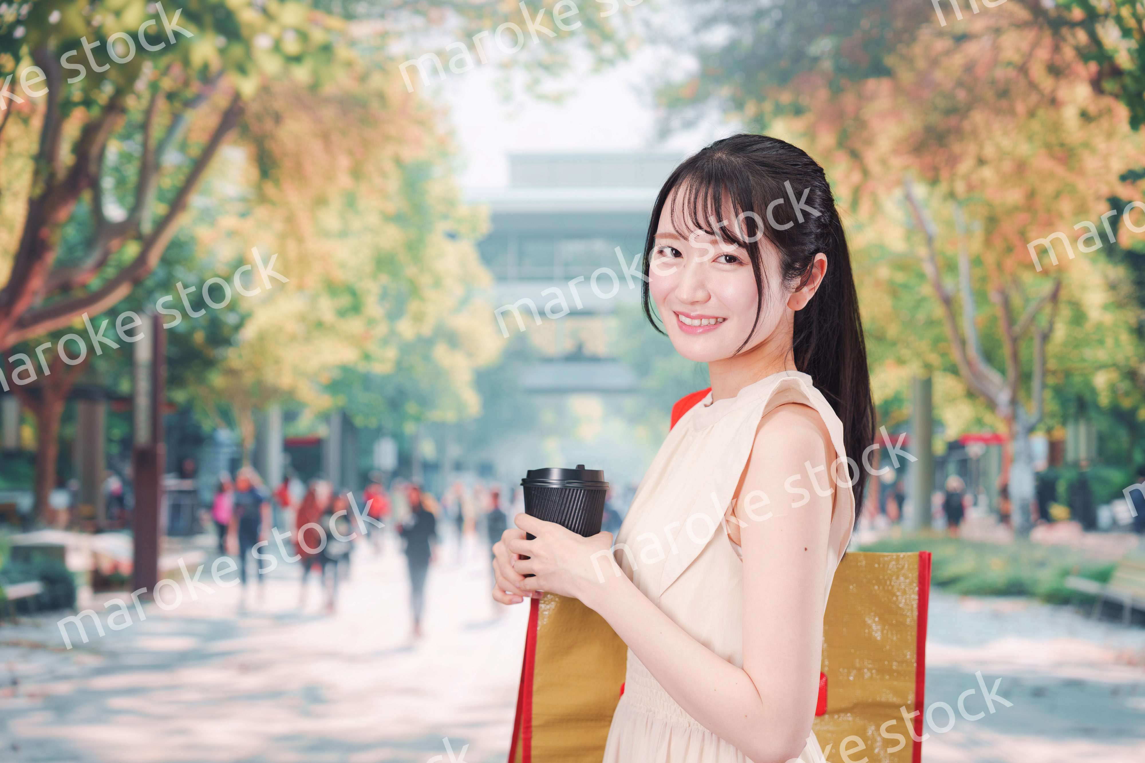 コーヒーを飲みながら外を歩く若い学生