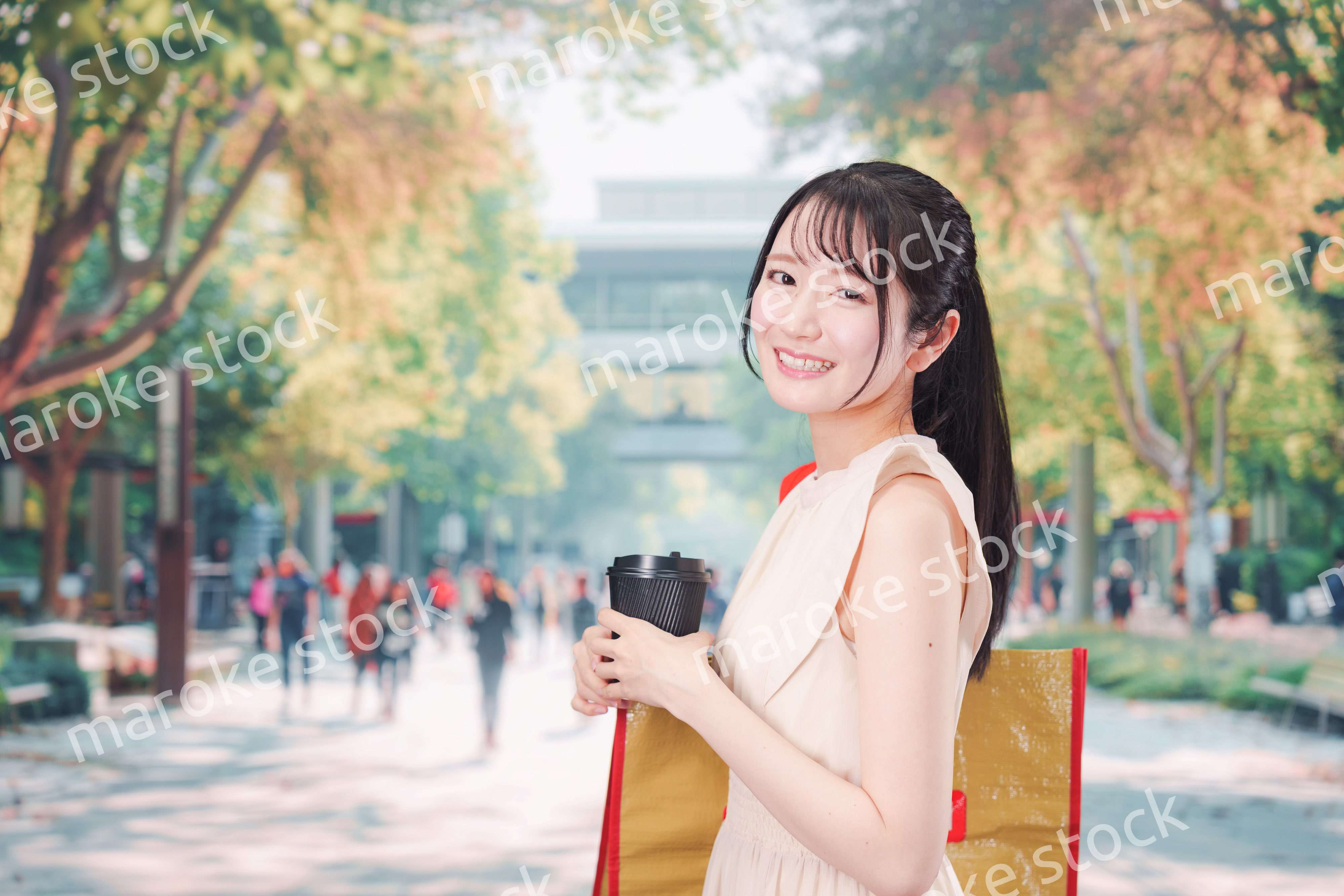 コーヒーを飲みながら外を歩く若い学生