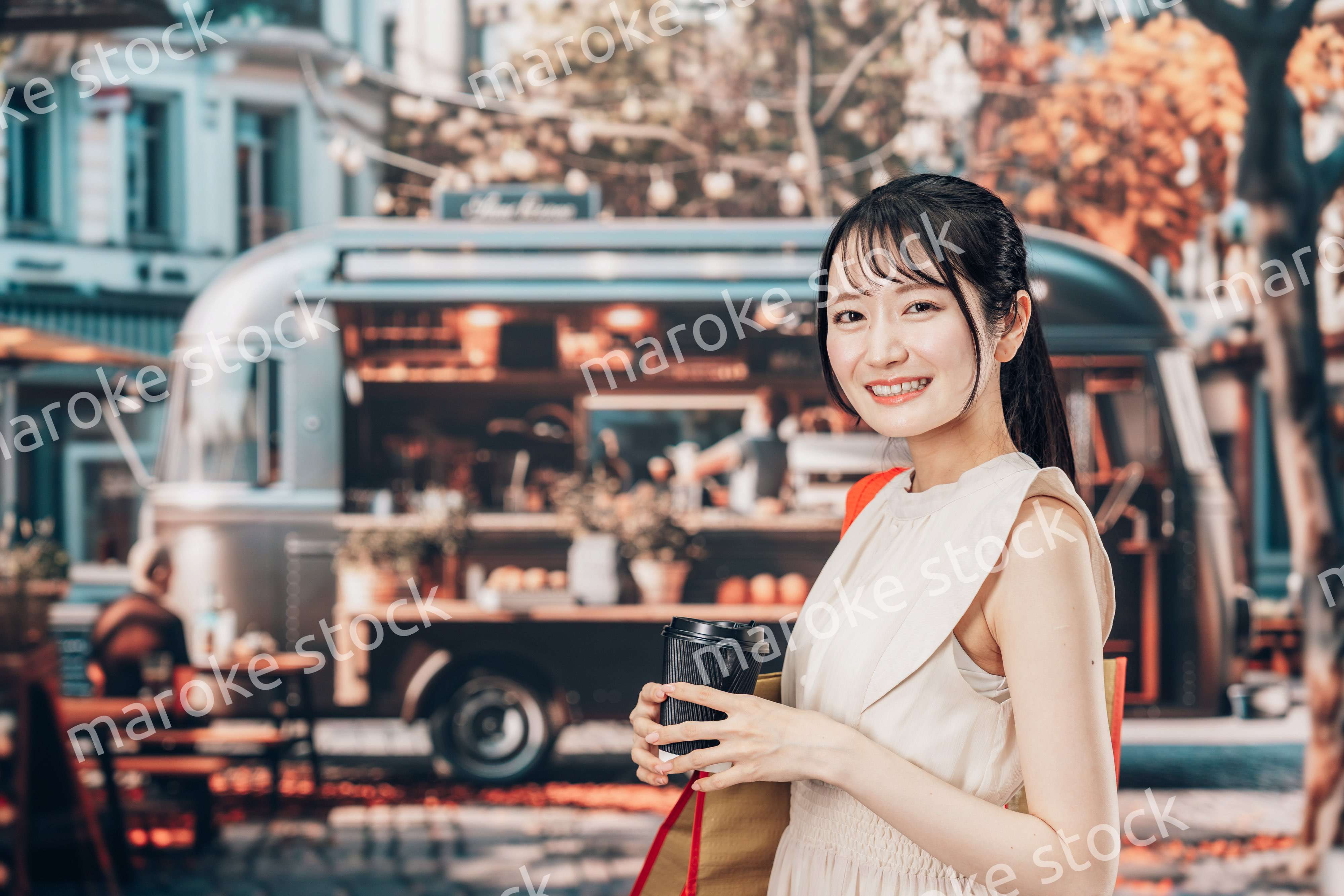 屋外のマーケットプレイスで飲食を楽しむ若い女性