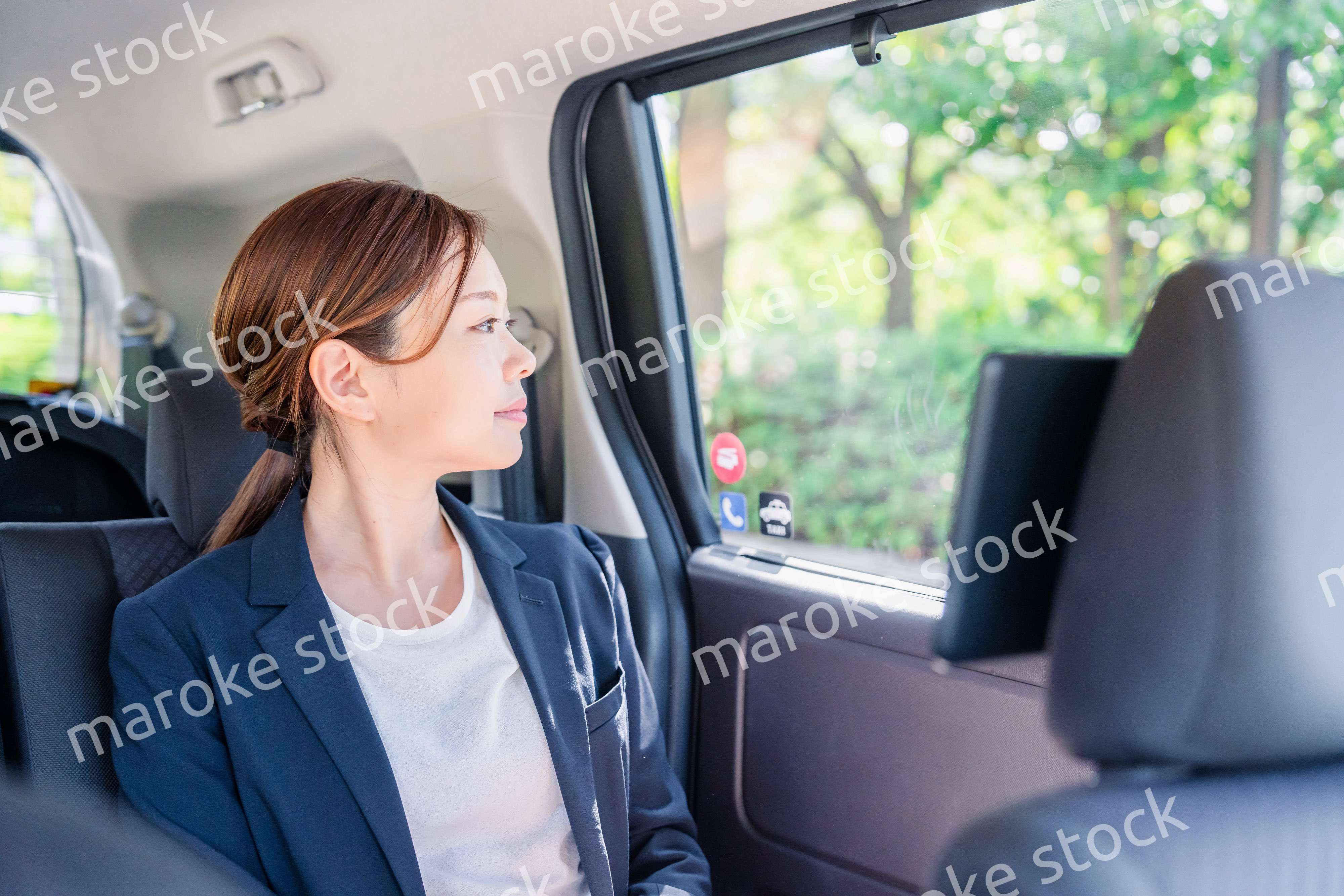タクシーの後部座席に座るキャリアウーマン