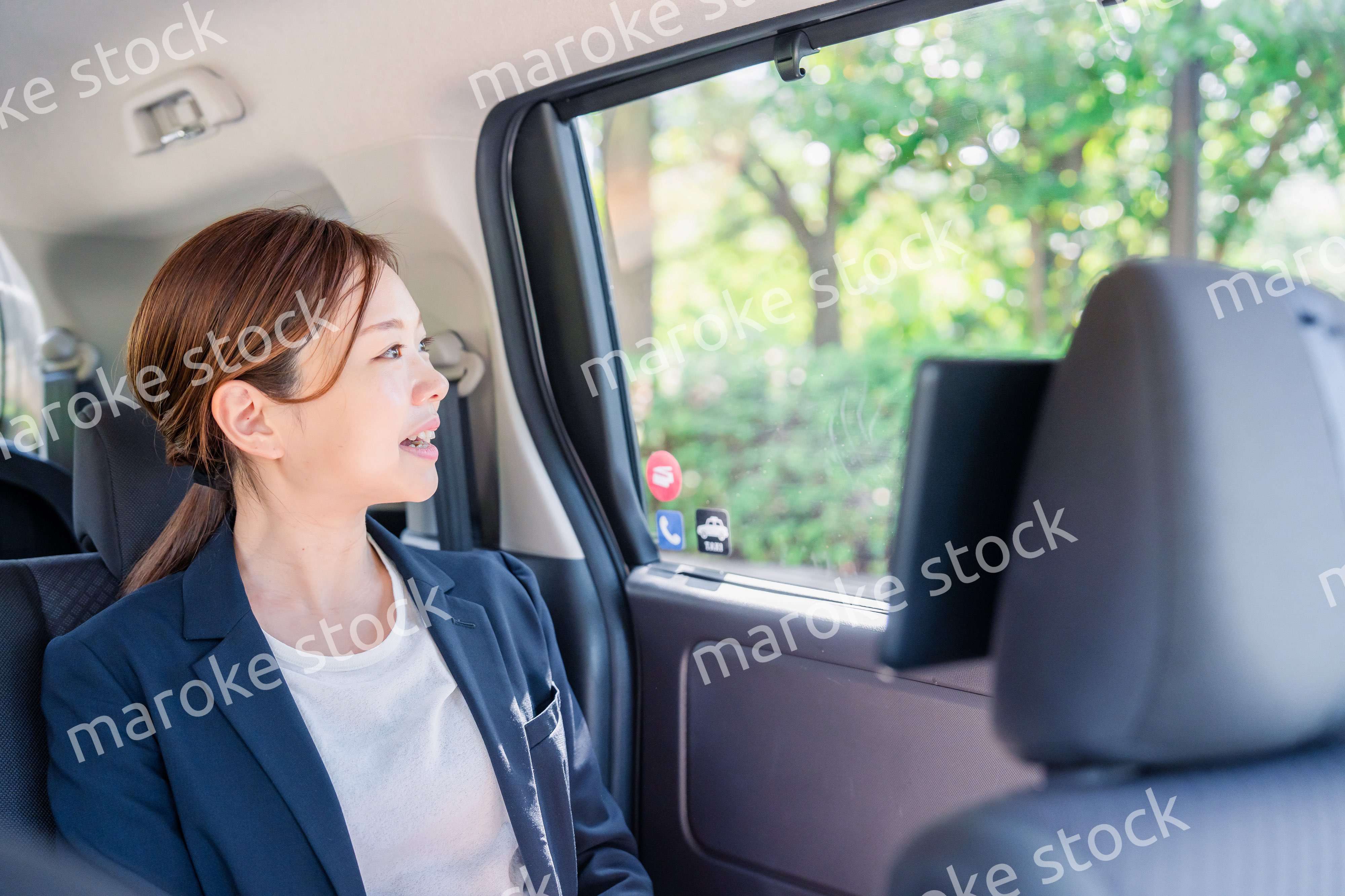 タクシーの後部座席に座るキャリアウーマン