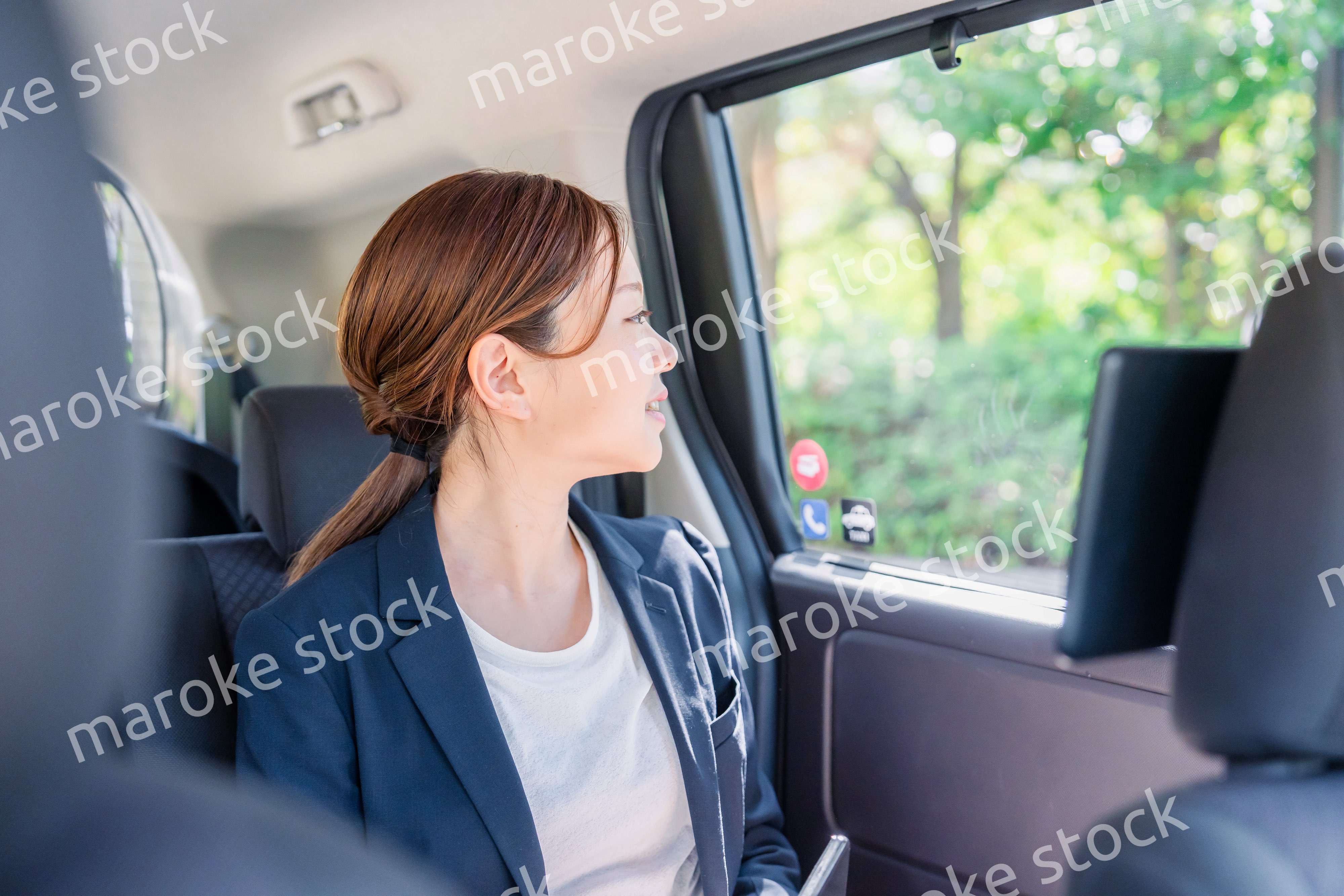 タクシーの後部座席に座るキャリアウーマン