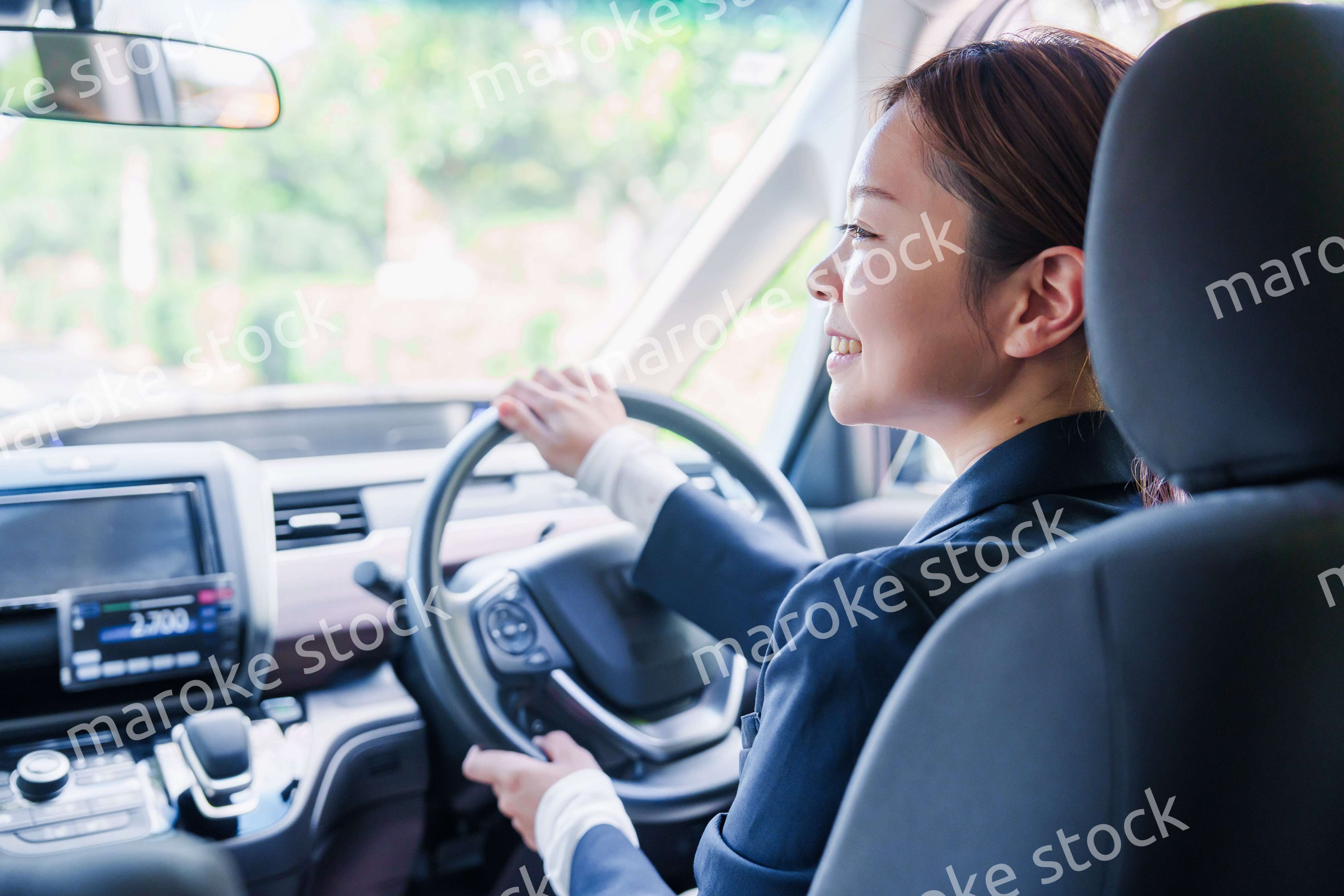 笑顔で運転をするタクシードライバーの女性