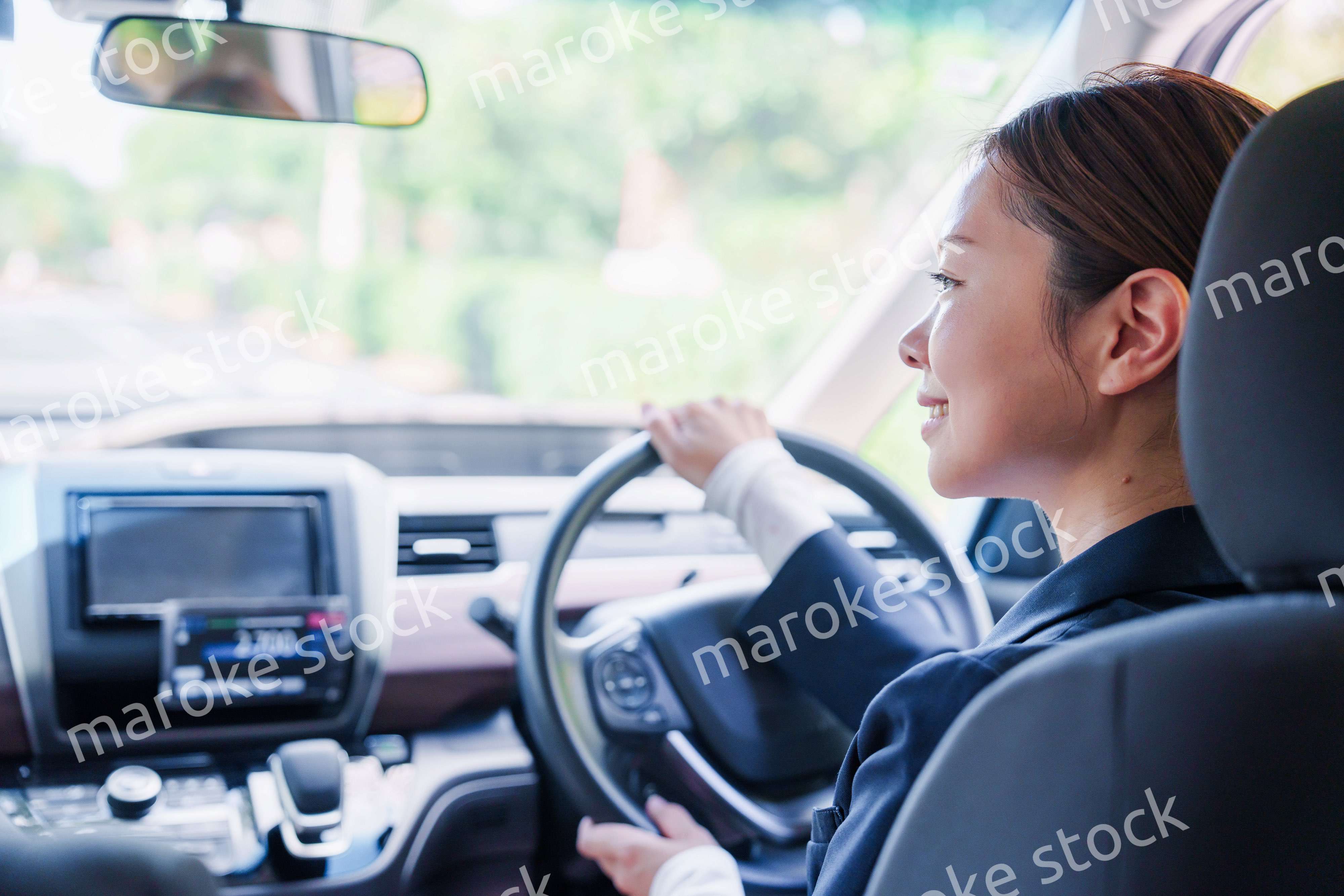 笑顔で運転をするタクシードライバーの女性