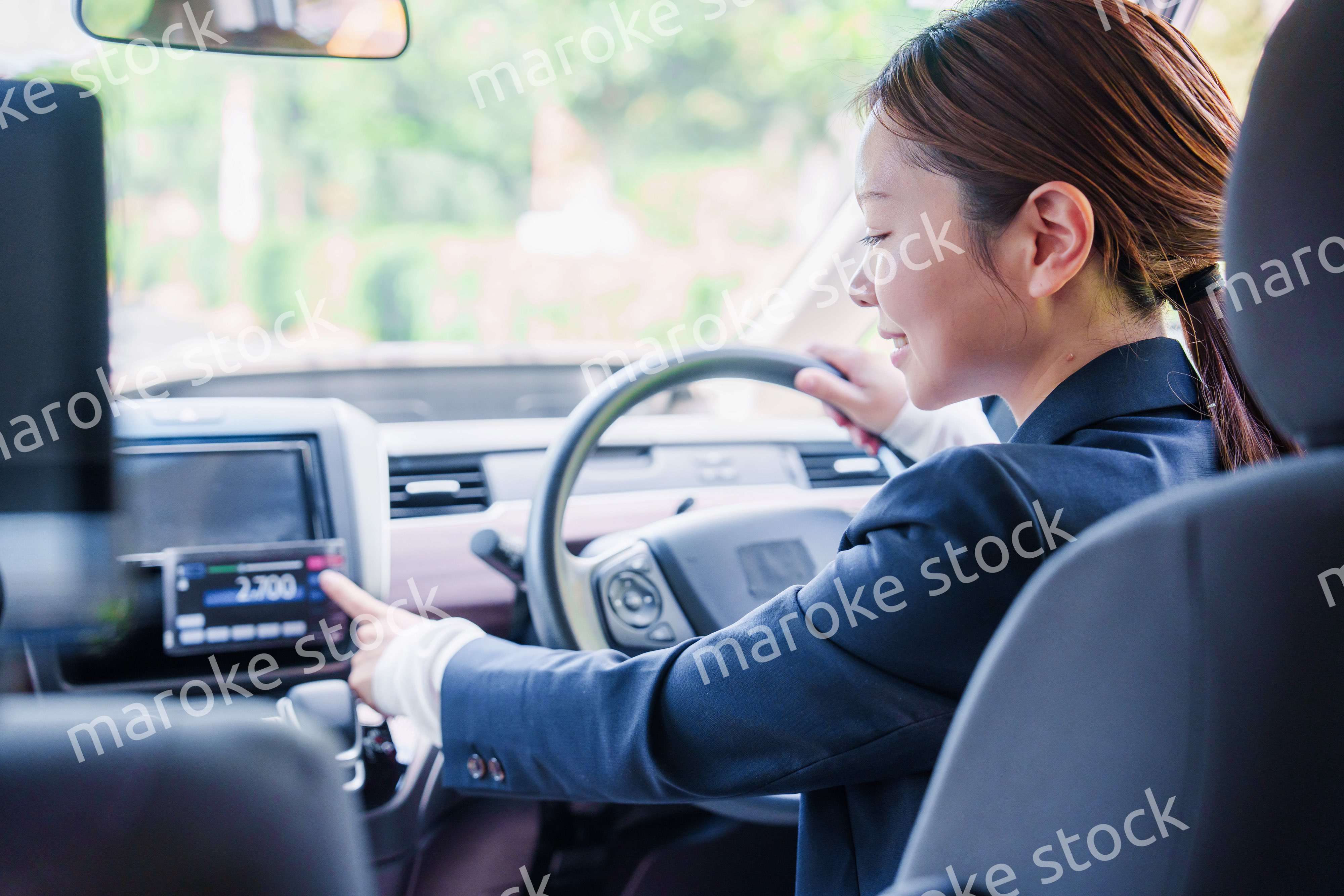 笑顔で料金の案内をするタクシードライバーの女性