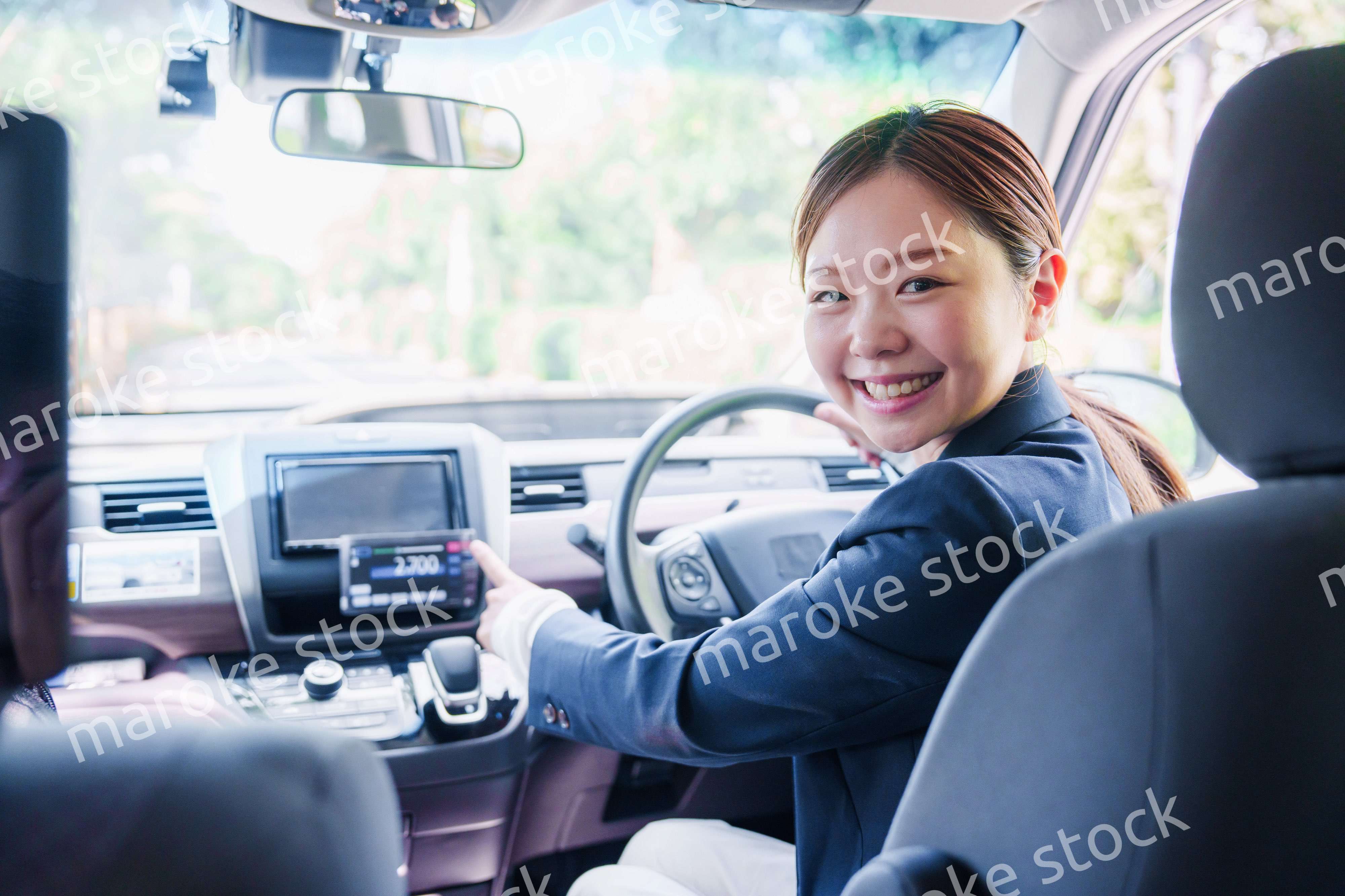 笑顔で料金の案内をするタクシードライバーの女性