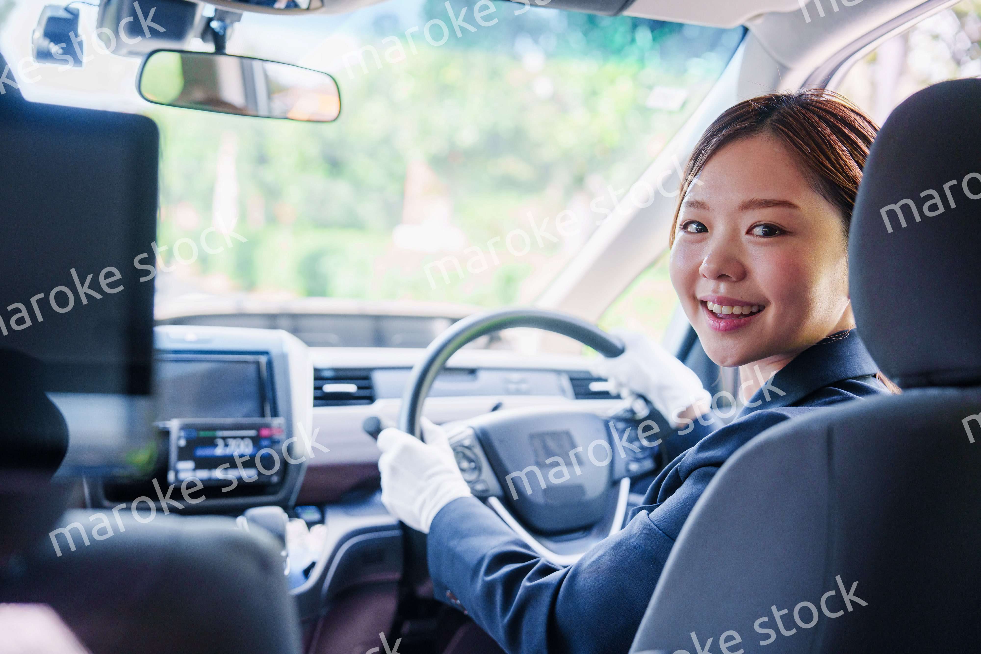 笑顔で運転をするタクシードライバーの女性
