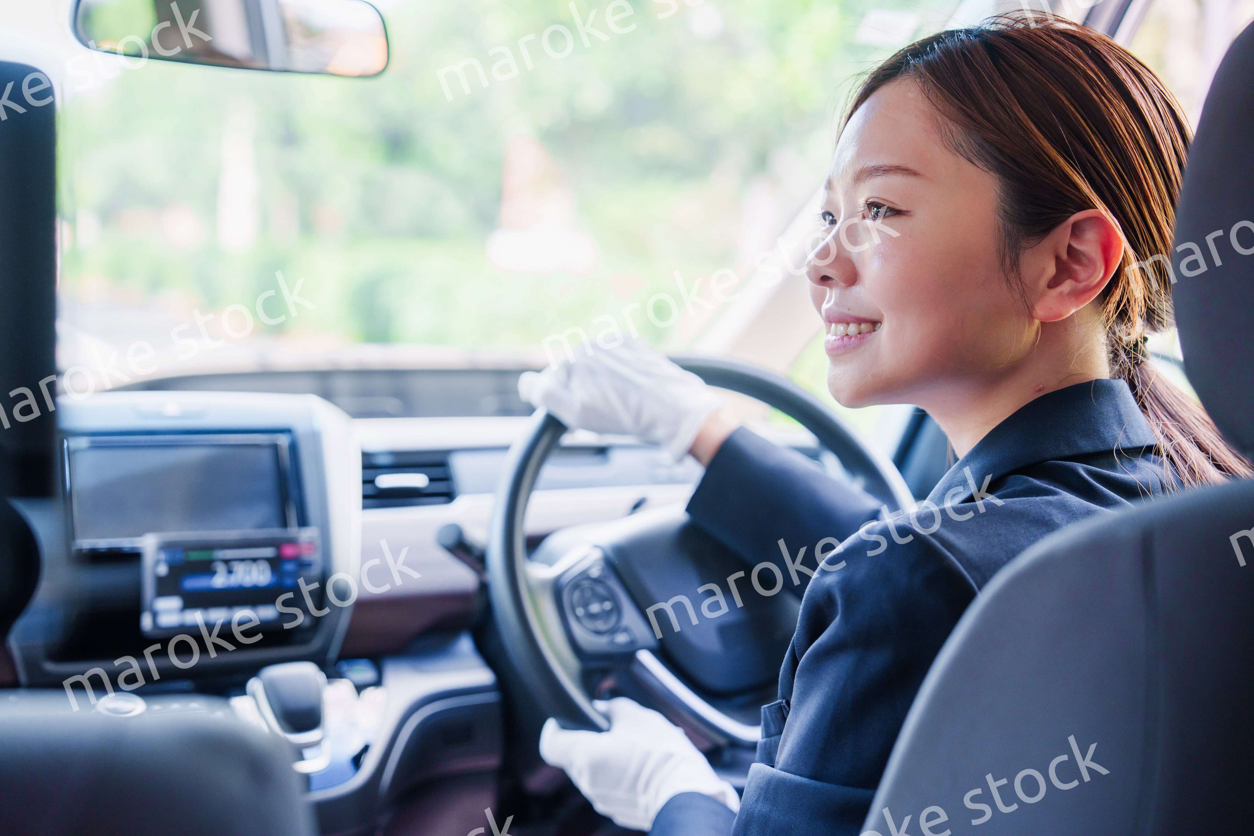 笑顔で運転をするタクシードライバーの女性