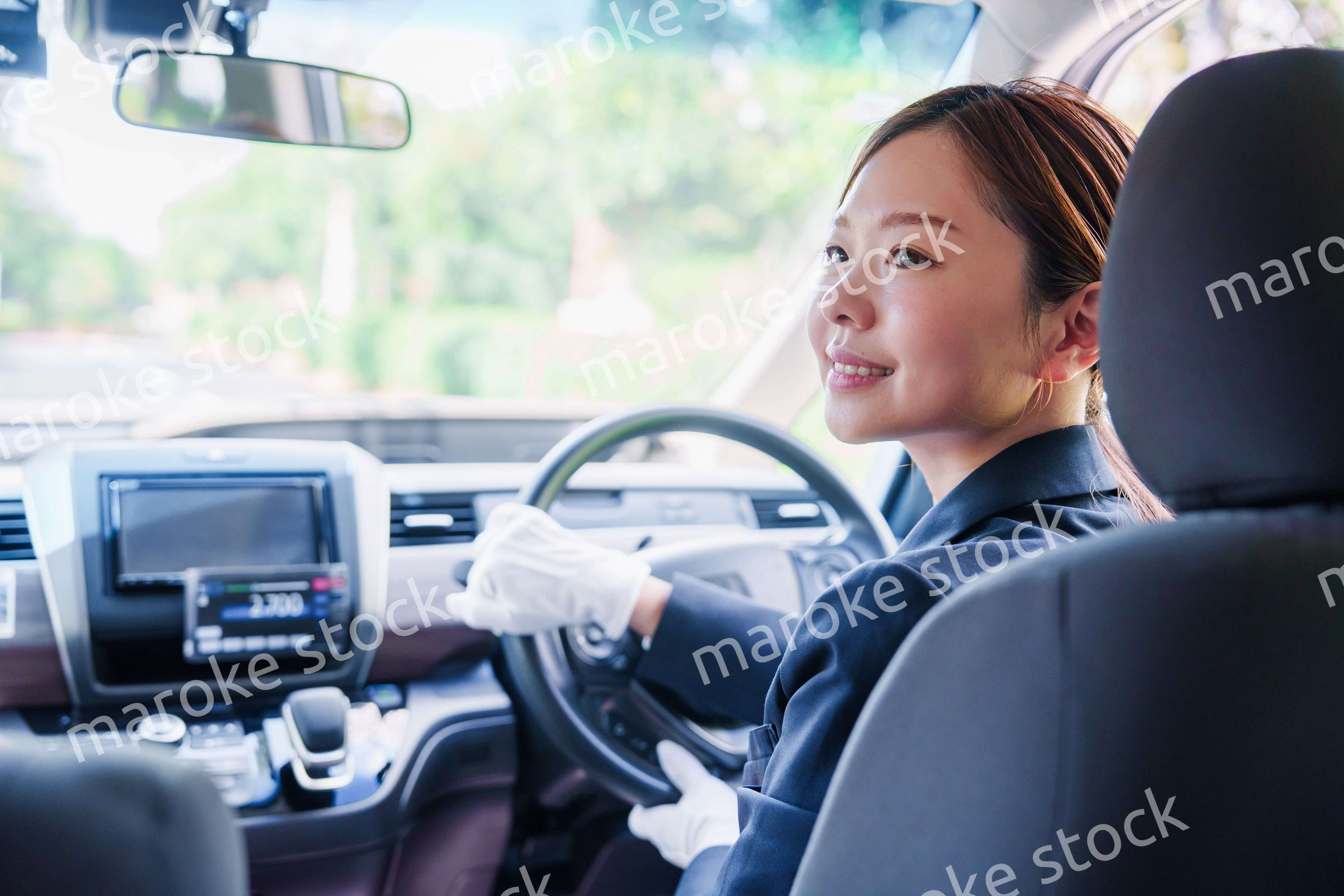 笑顔で運転をするタクシードライバーの女性