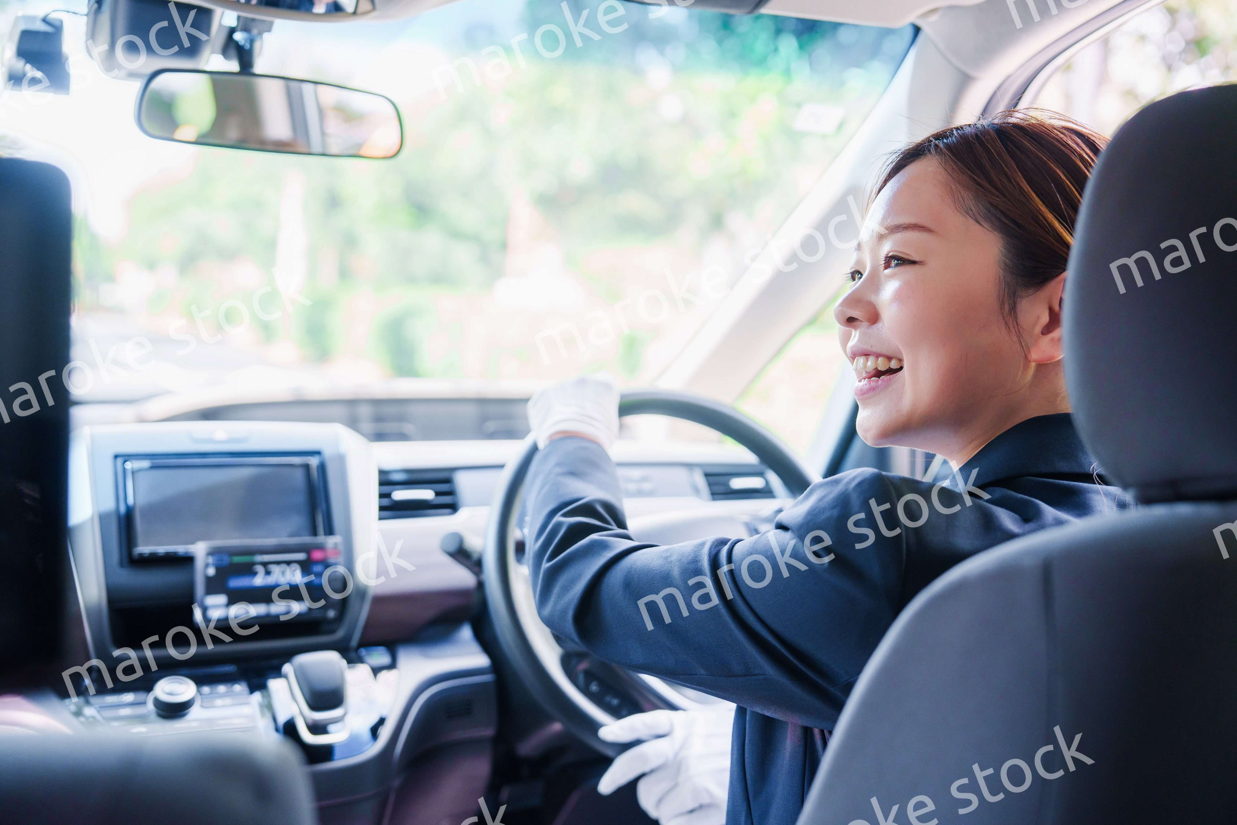 笑顔で運転をするタクシードライバーの女性