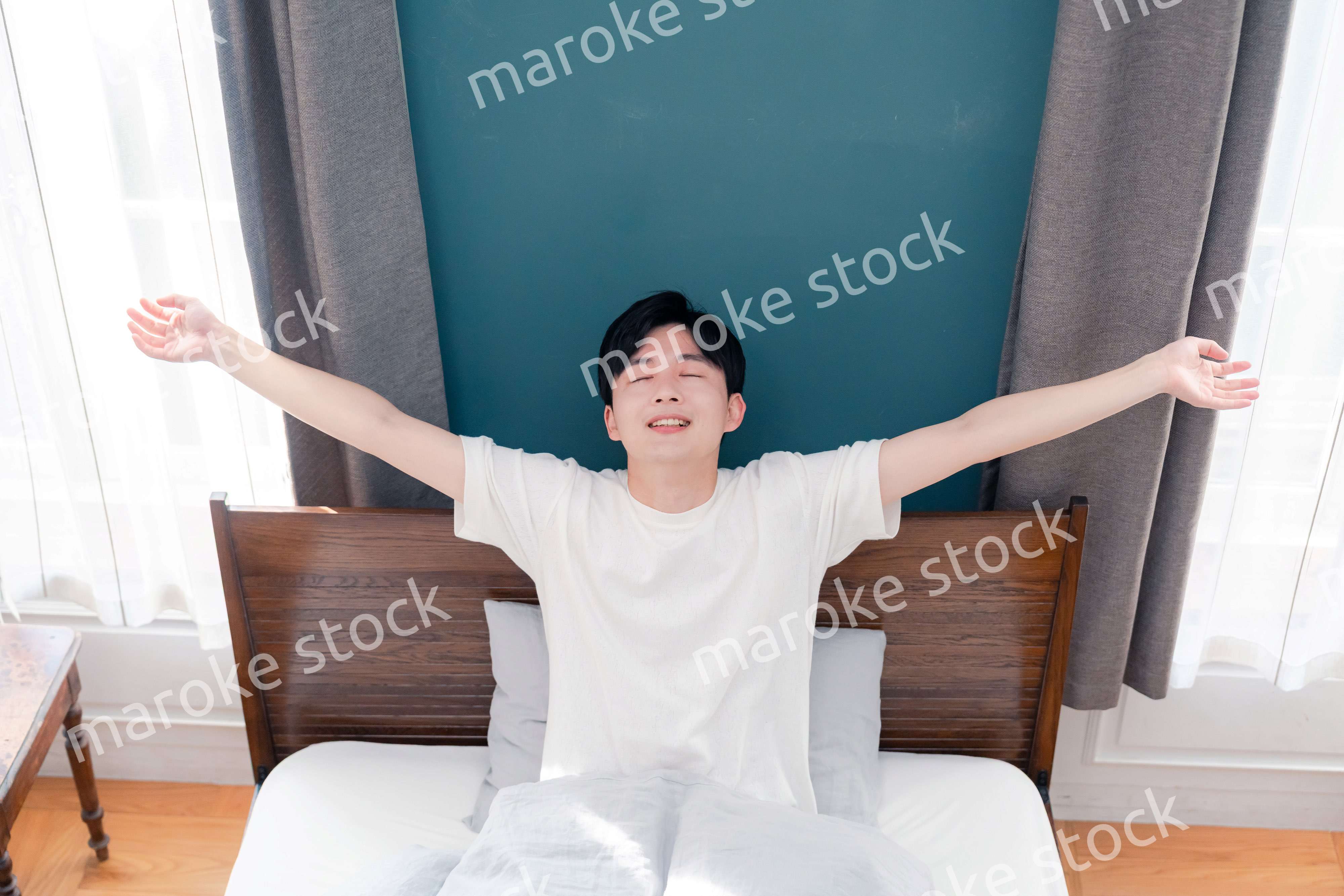 朝日が差し込む中で爽やかに目覚める若い男性