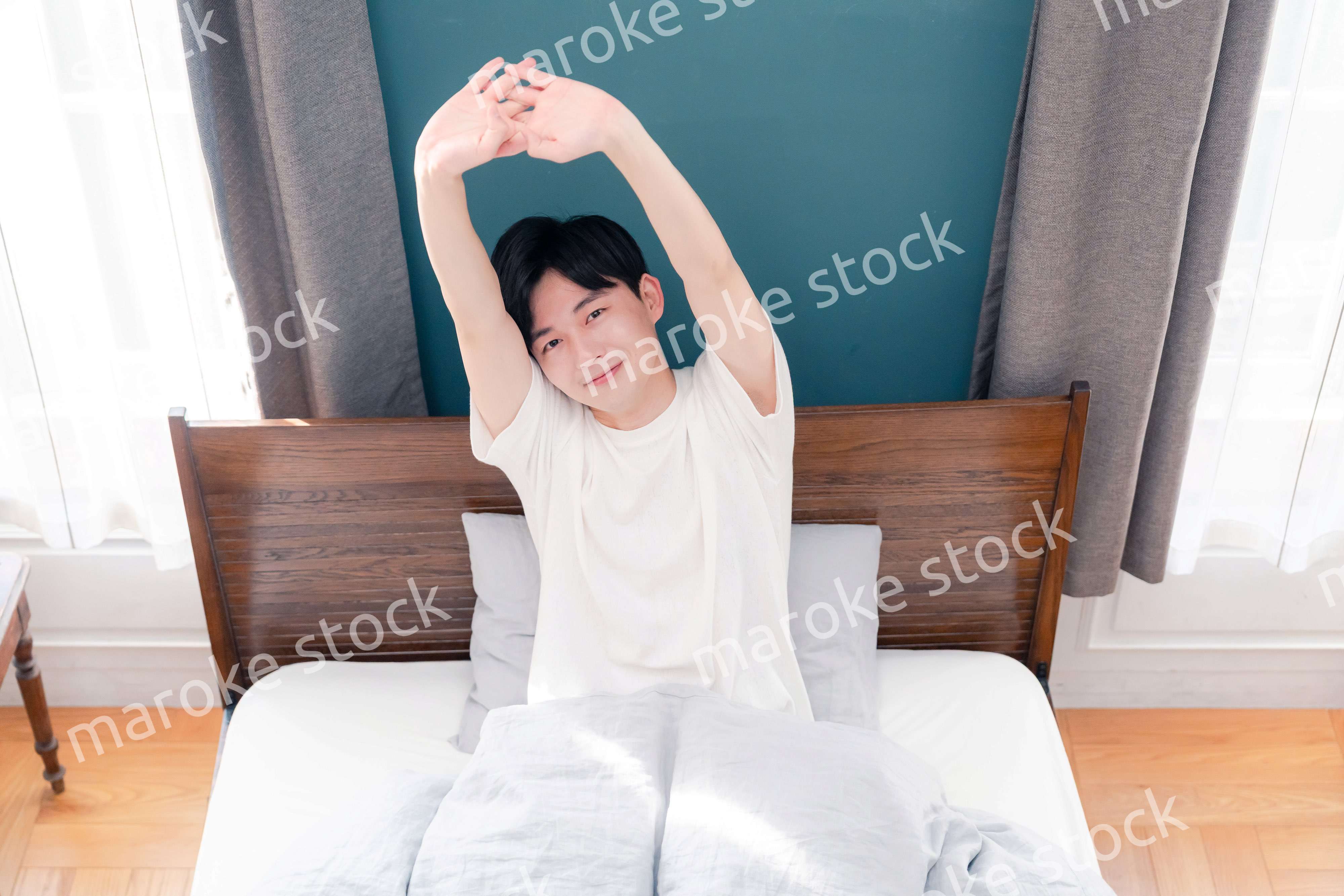 朝日が差し込む中で爽やかに目覚める若い男性