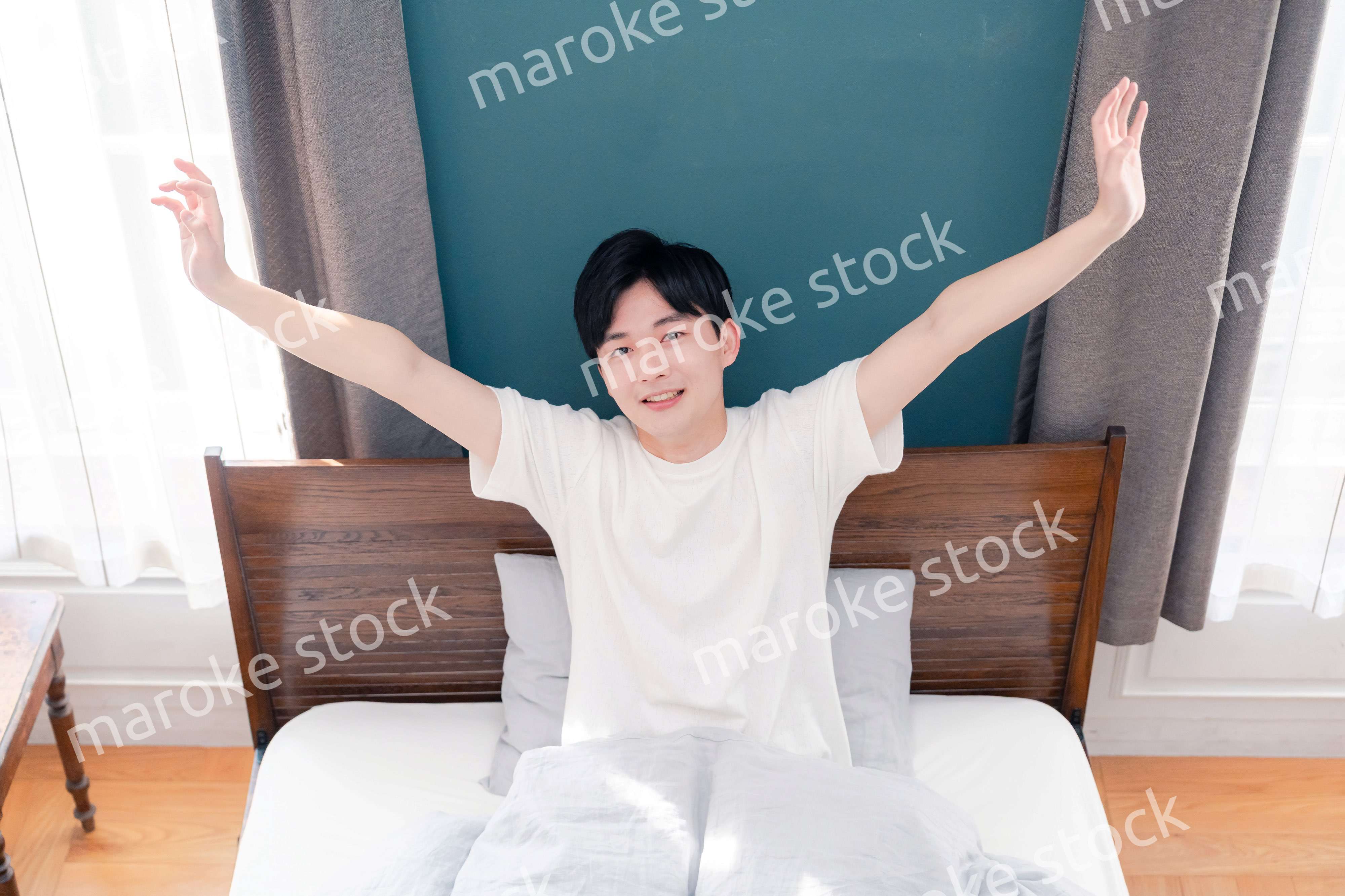 朝日が差し込む中で爽やかに目覚める若い男性