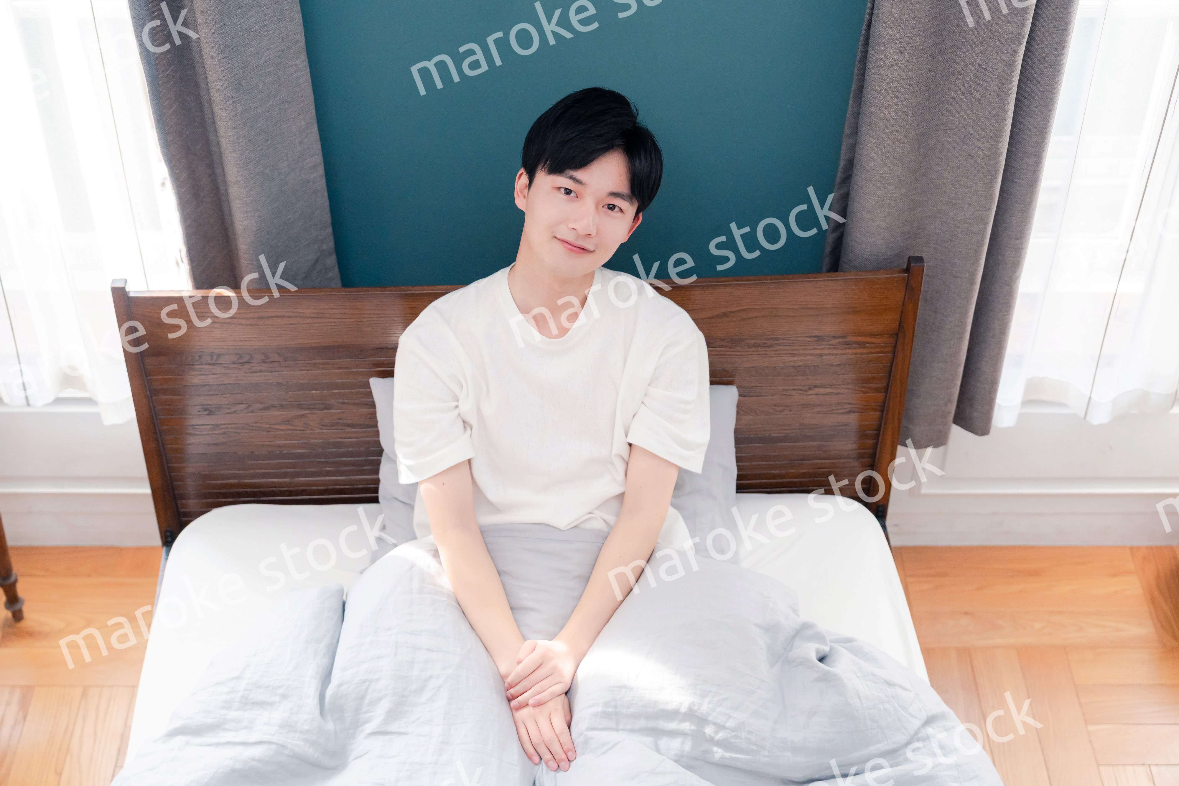 朝日が差し込む中で爽やかに目覚める若い男性