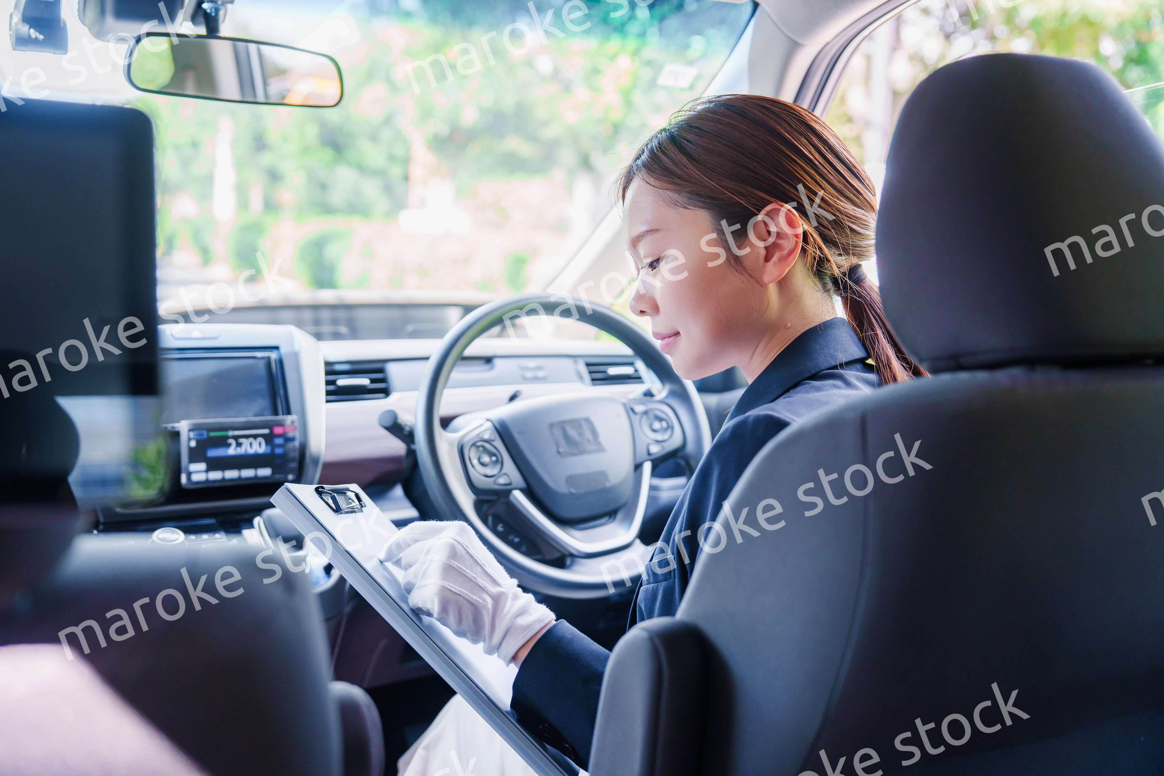 笑顔で運転をするタクシードライバーの女性