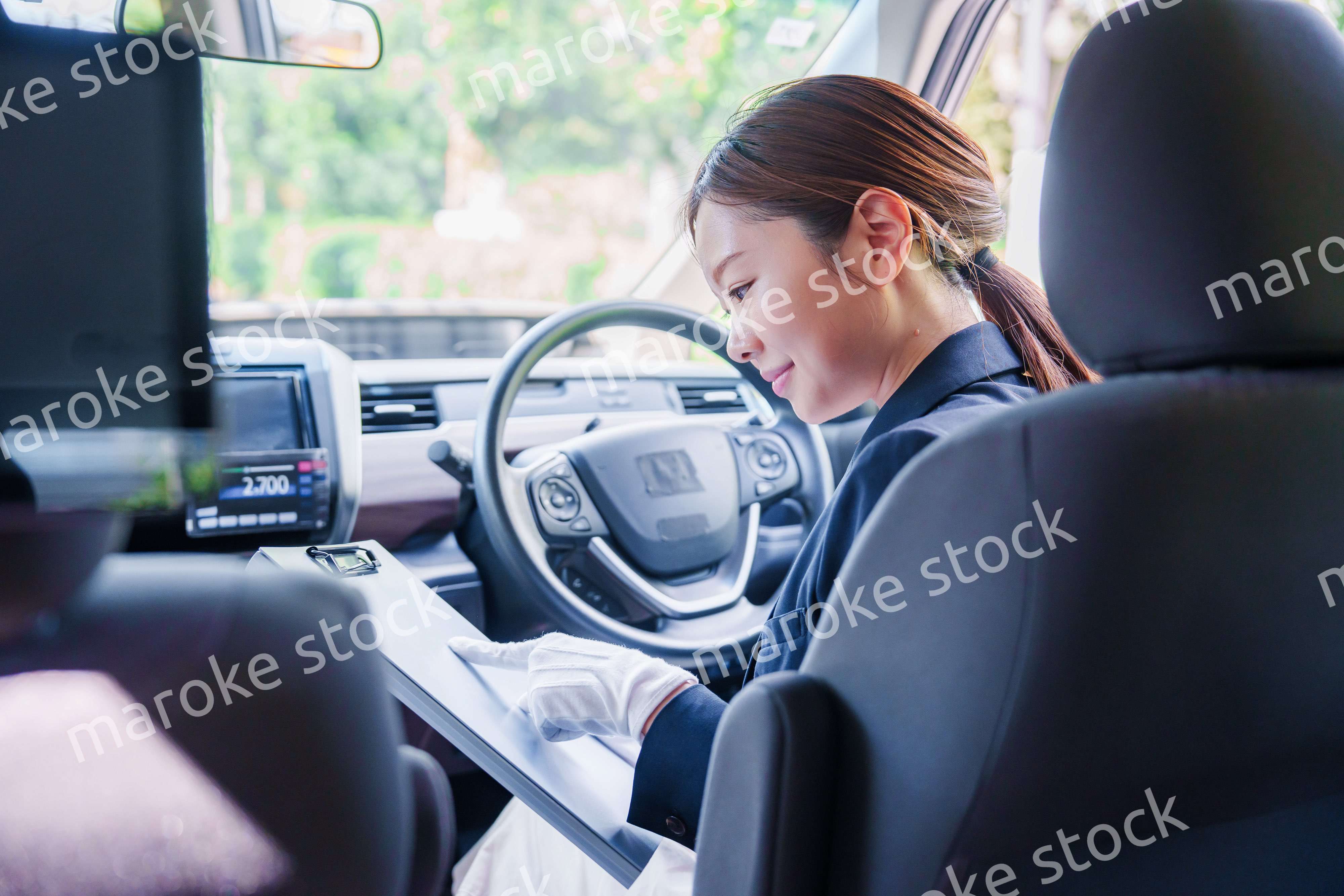 笑顔で運転をするタクシードライバーの女性