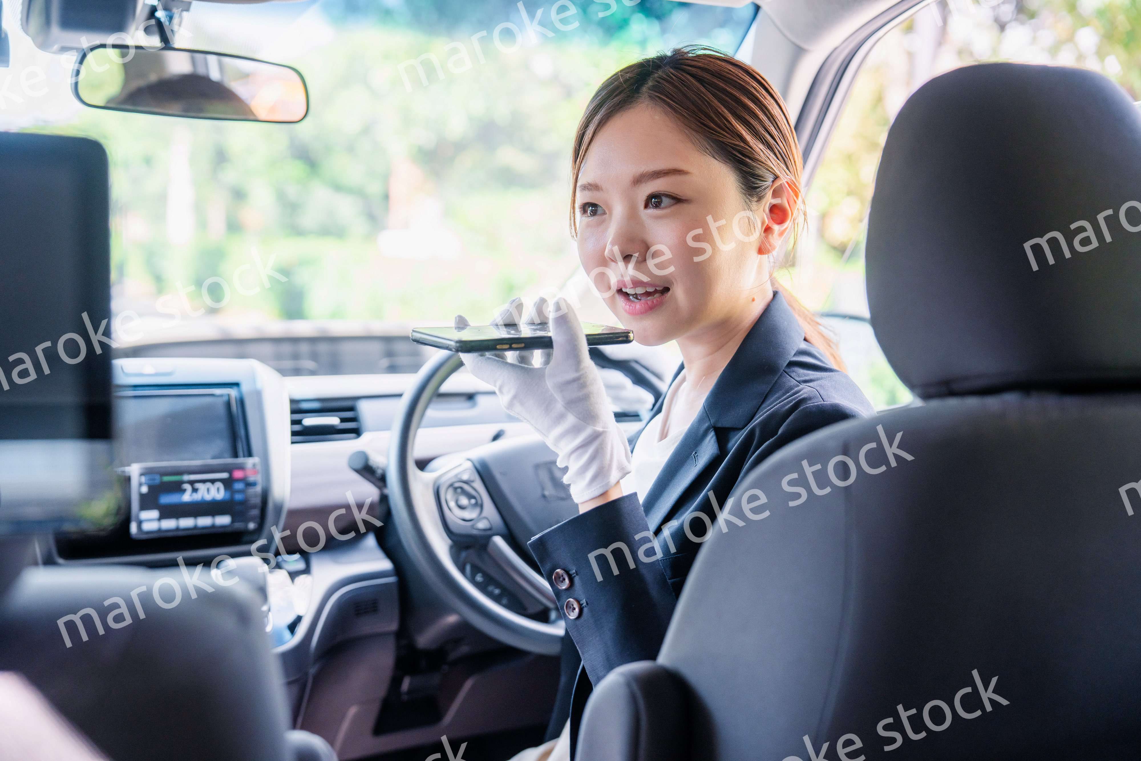 外国人への接客のために翻訳アプリを使う女性タクシードライバー