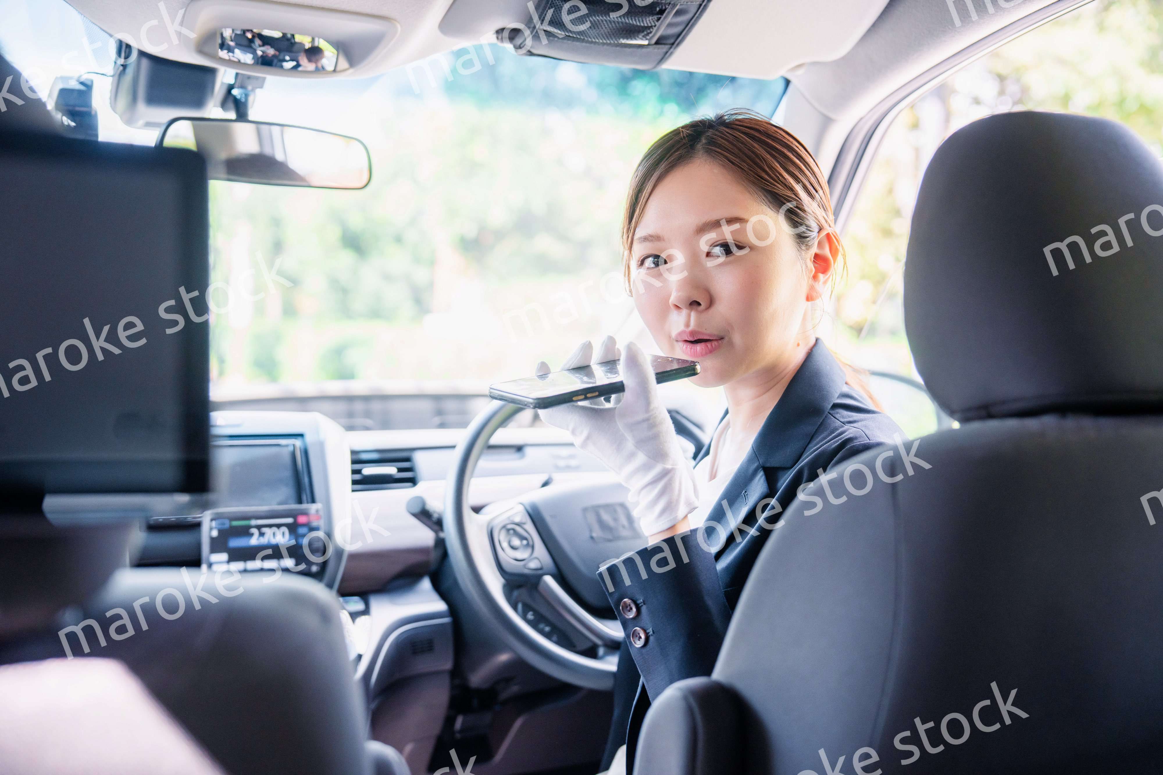 外国人への接客のために翻訳アプリを使う女性タクシードライバー