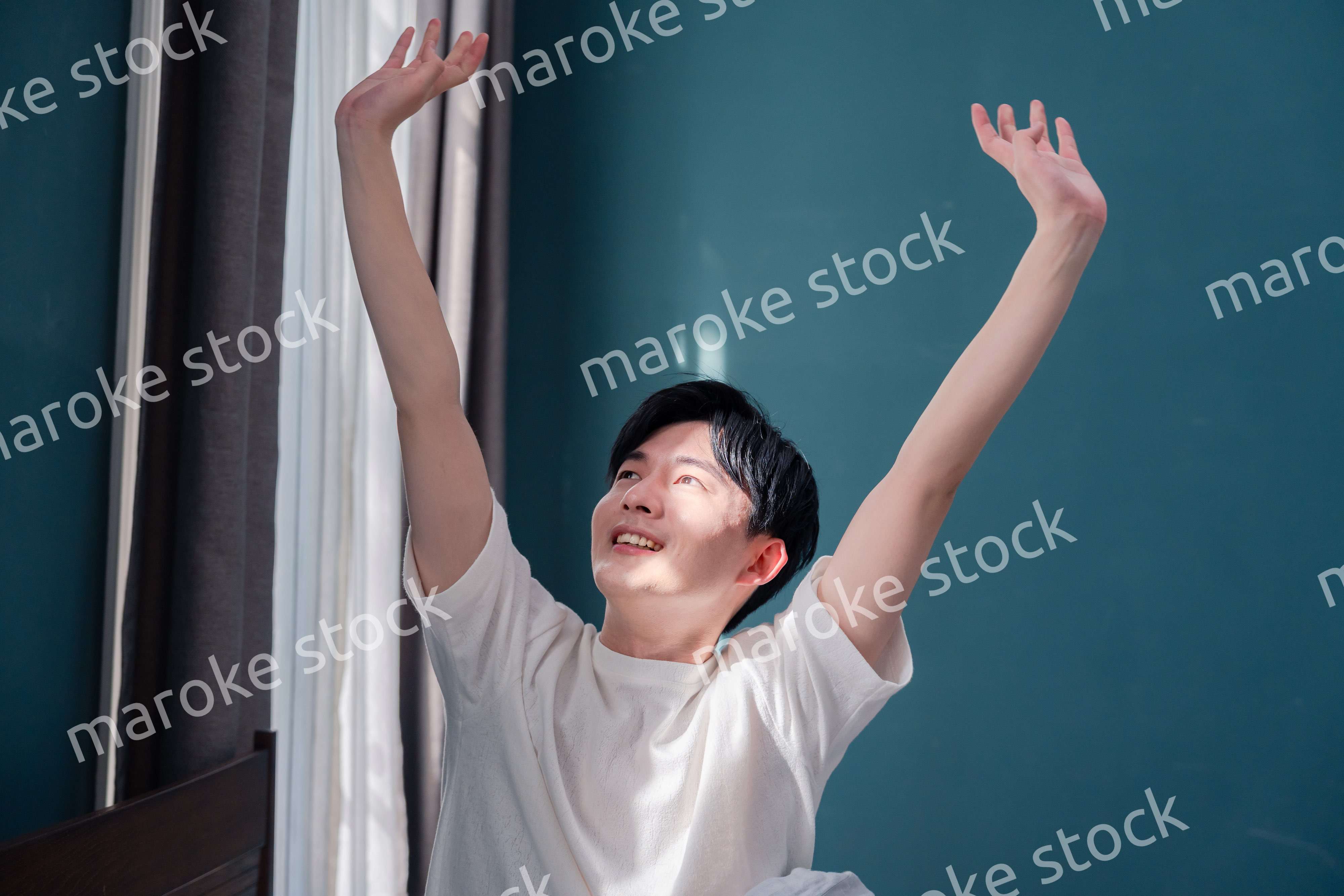 朝日が差し込む中で爽やかに目覚める若い男性