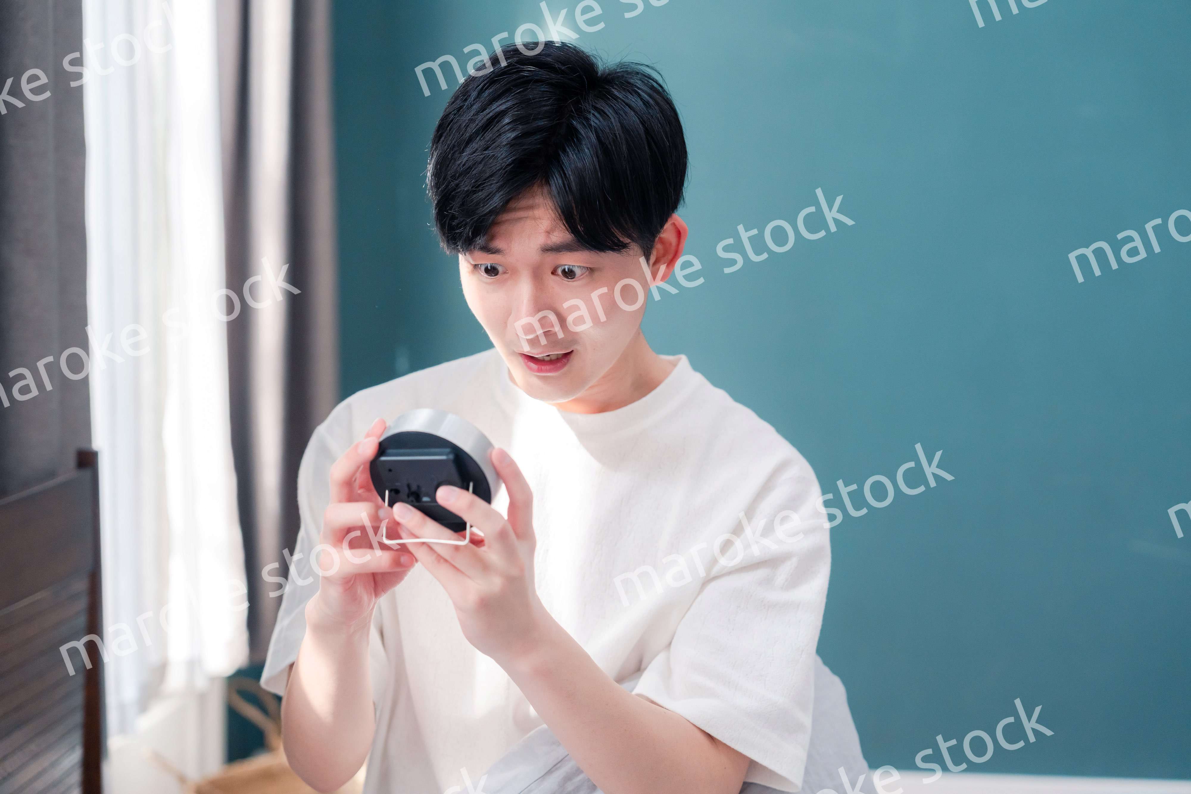 寝坊をして焦る若い男性