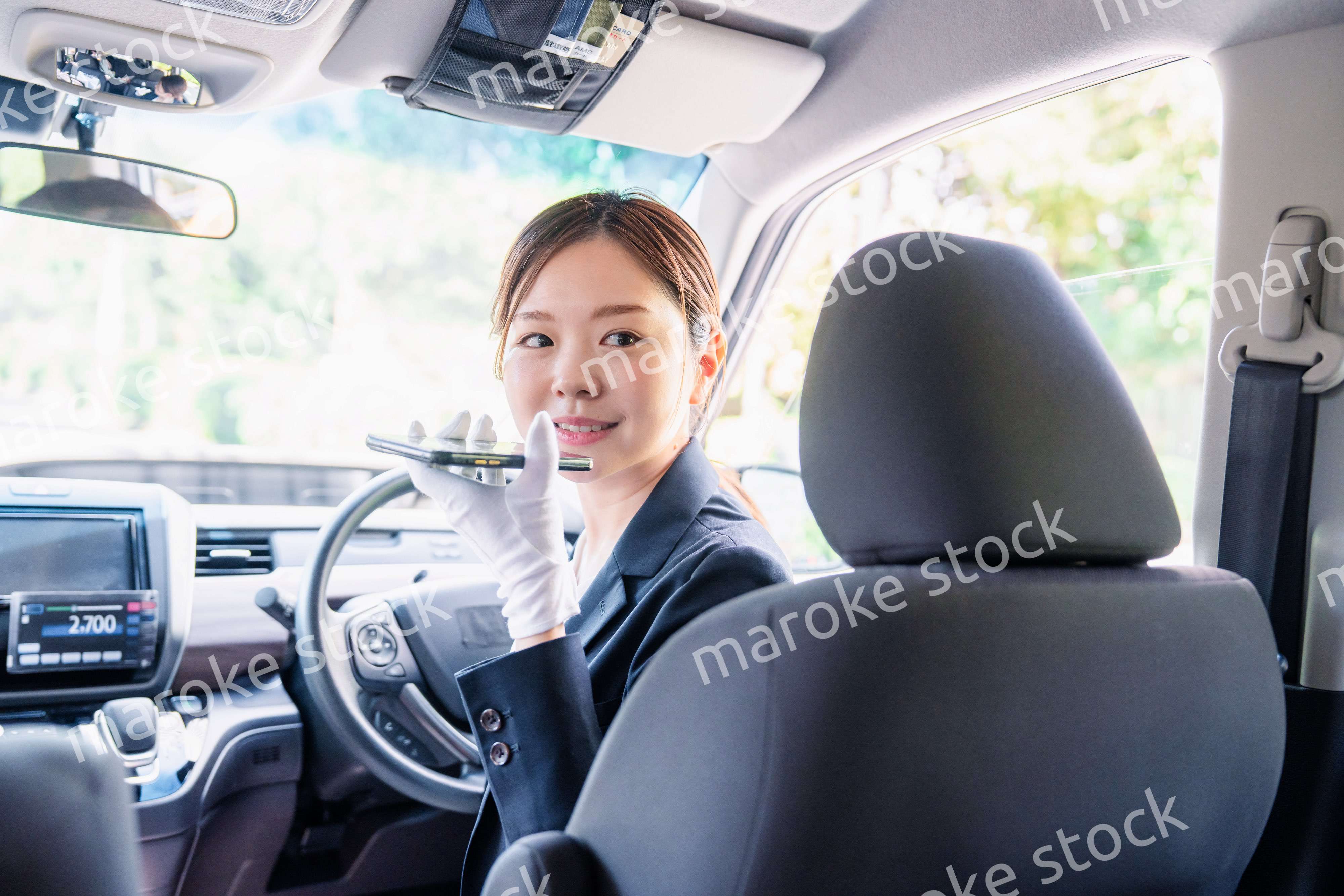 外国人への接客のために翻訳アプリを使う女性タクシードライバー