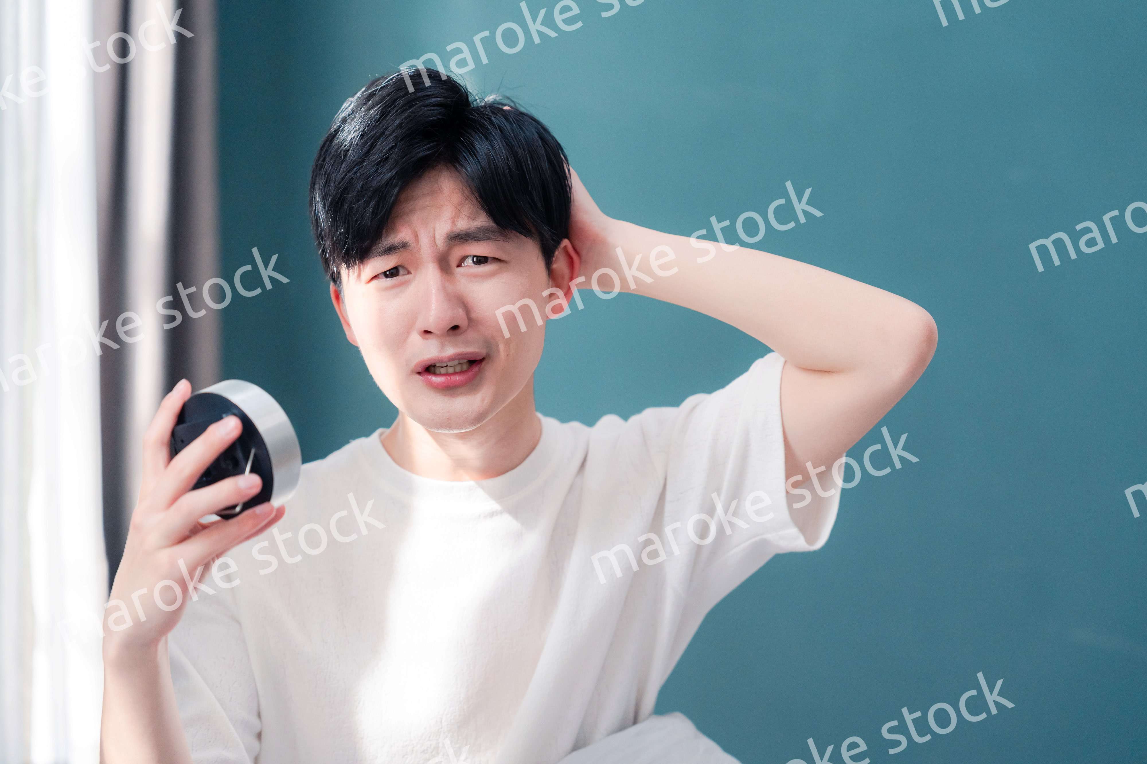 寝坊をして焦る若い男性