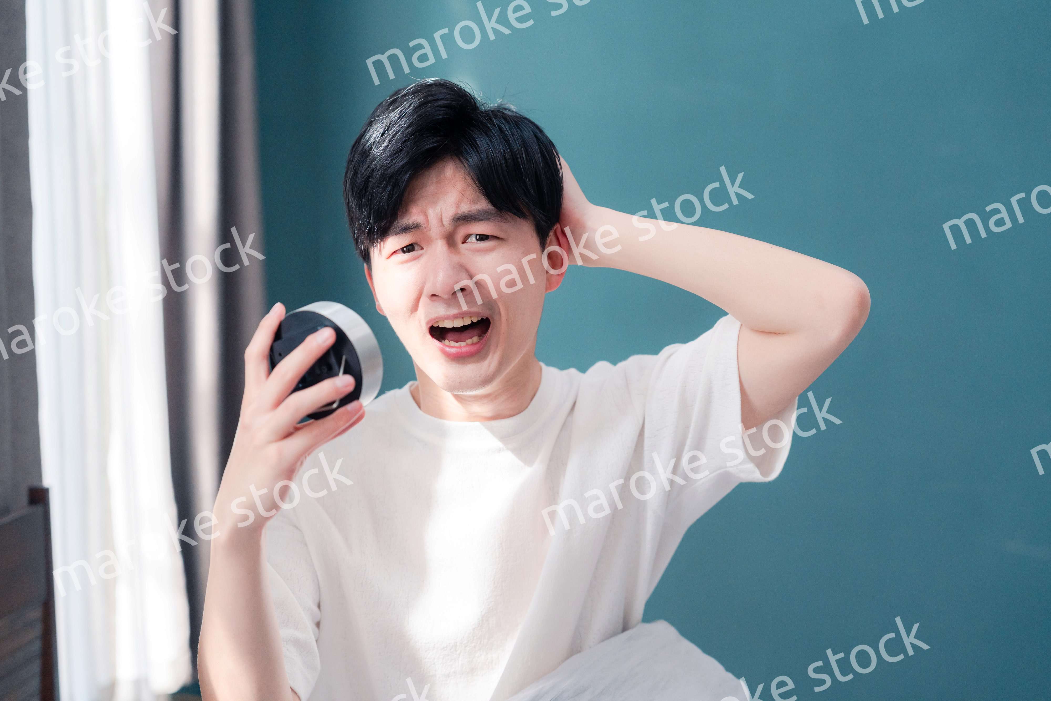 寝坊をして焦る若い男性