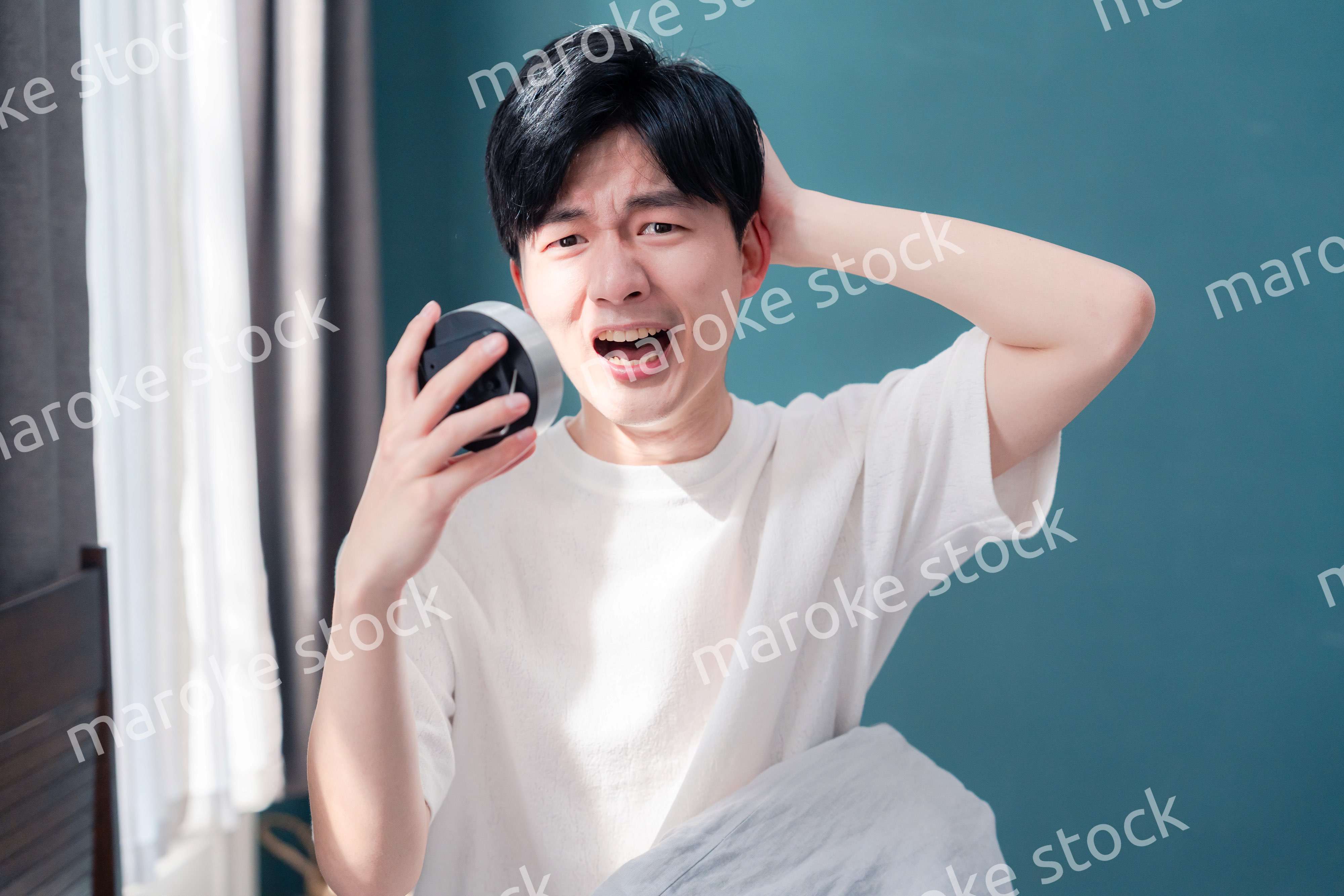 寝坊をして焦る若い男性