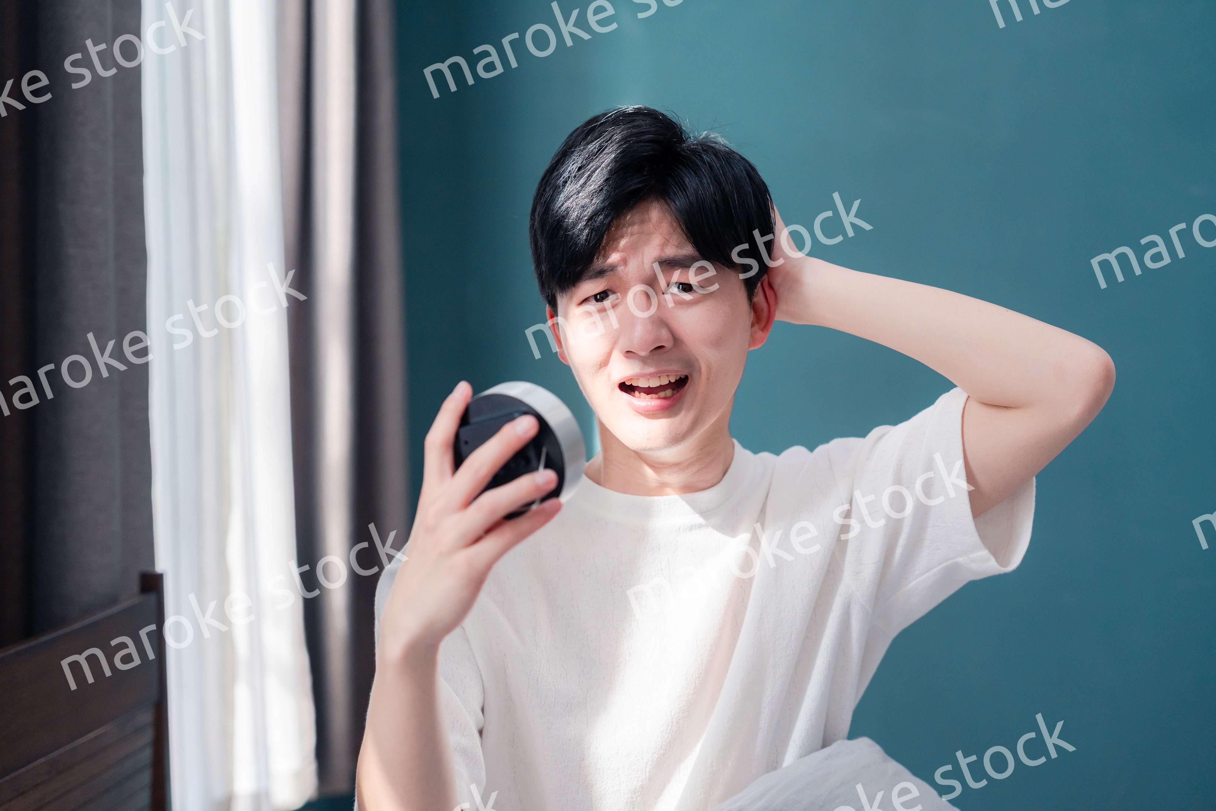 寝坊をして焦る若い男性