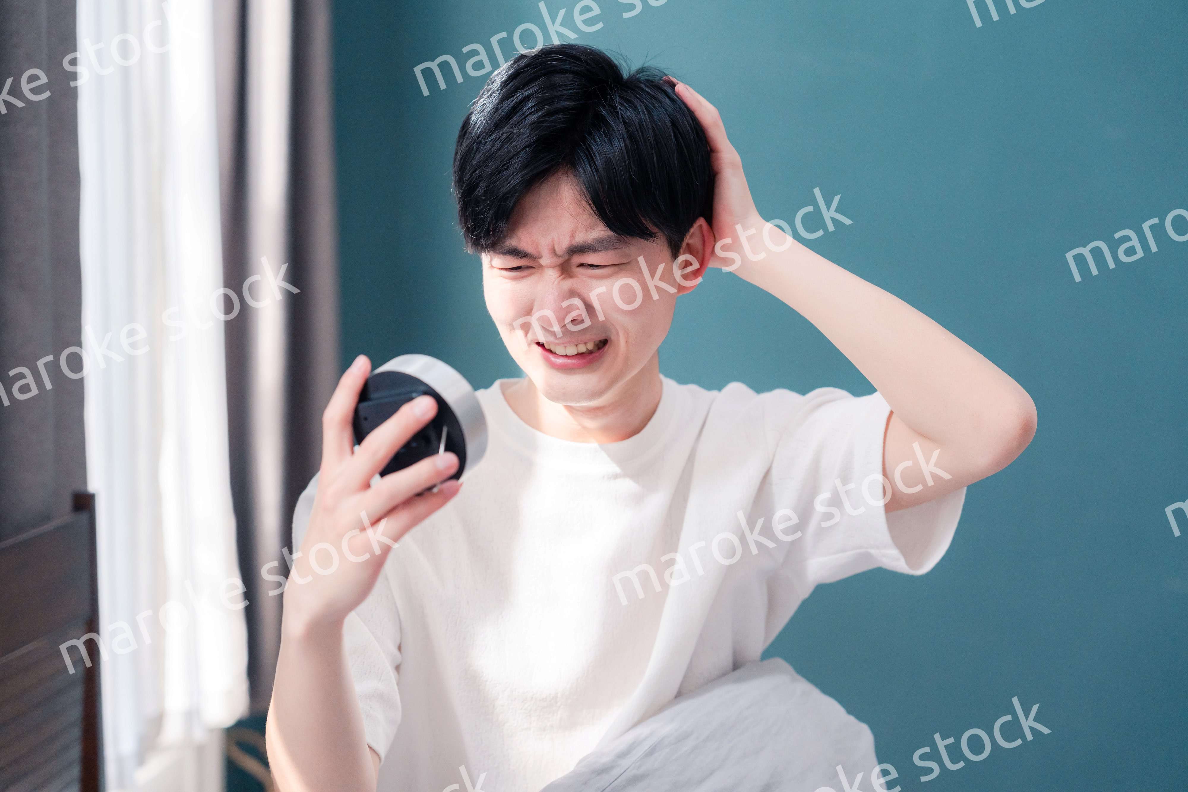 寝坊をして焦る若い男性