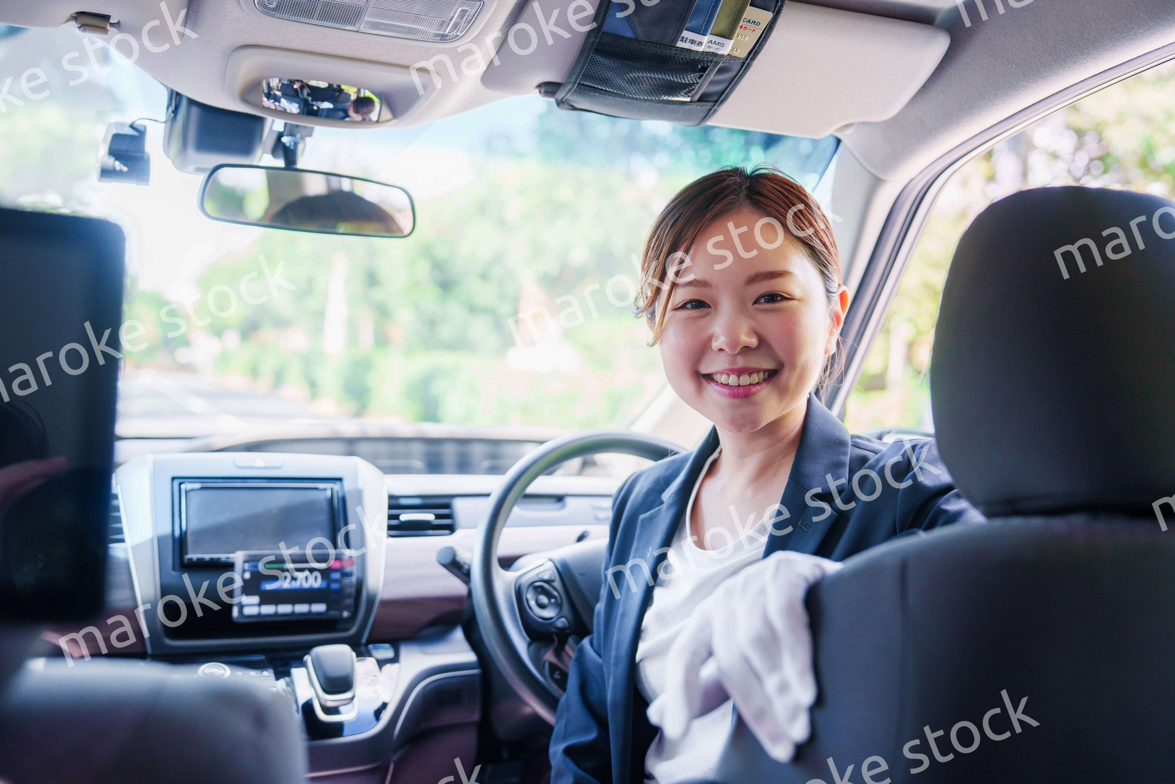 笑顔で運転をするタクシードライバーの女性