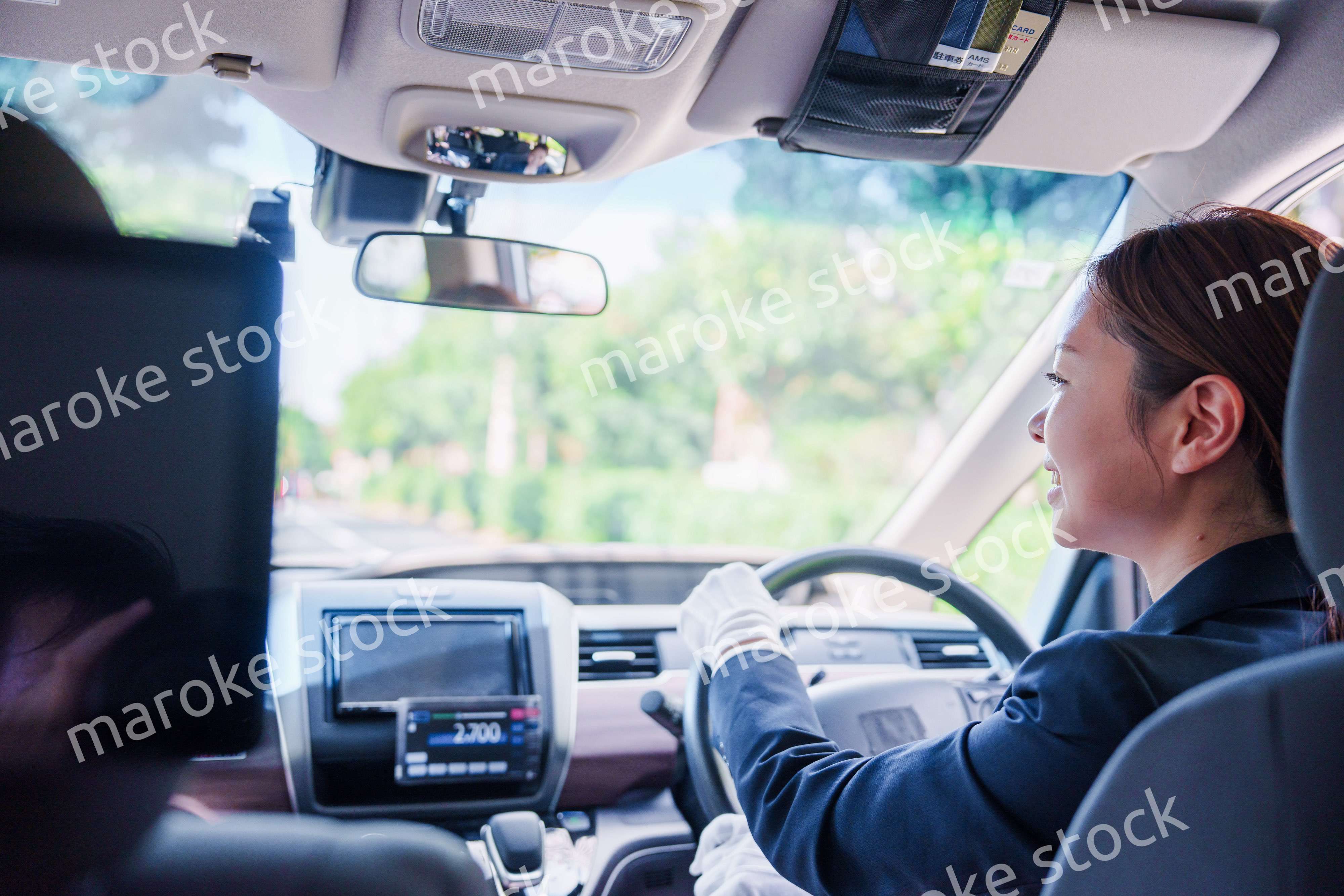 笑顔で運転をするタクシードライバーの女性