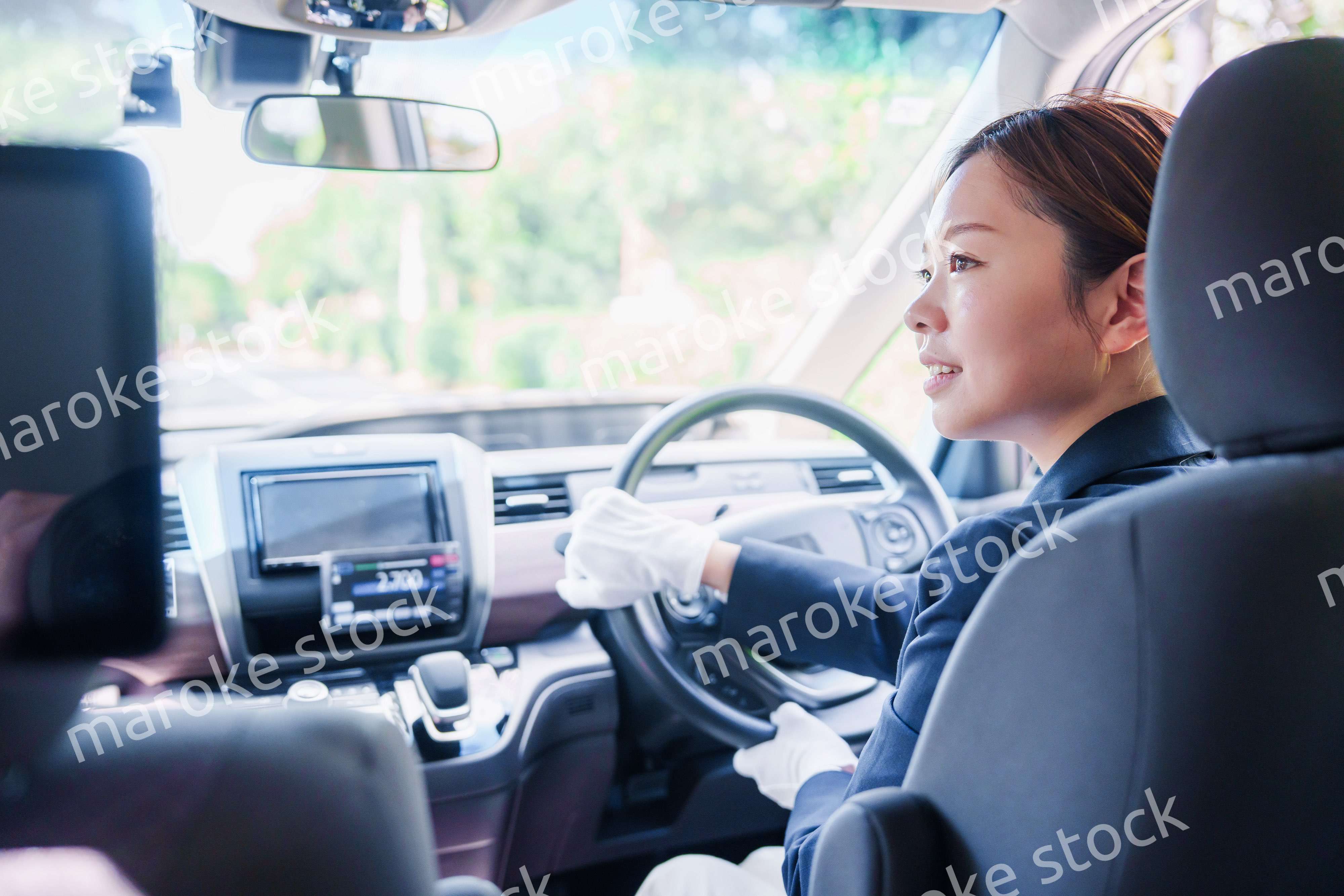 笑顔で運転をするタクシードライバーの女性