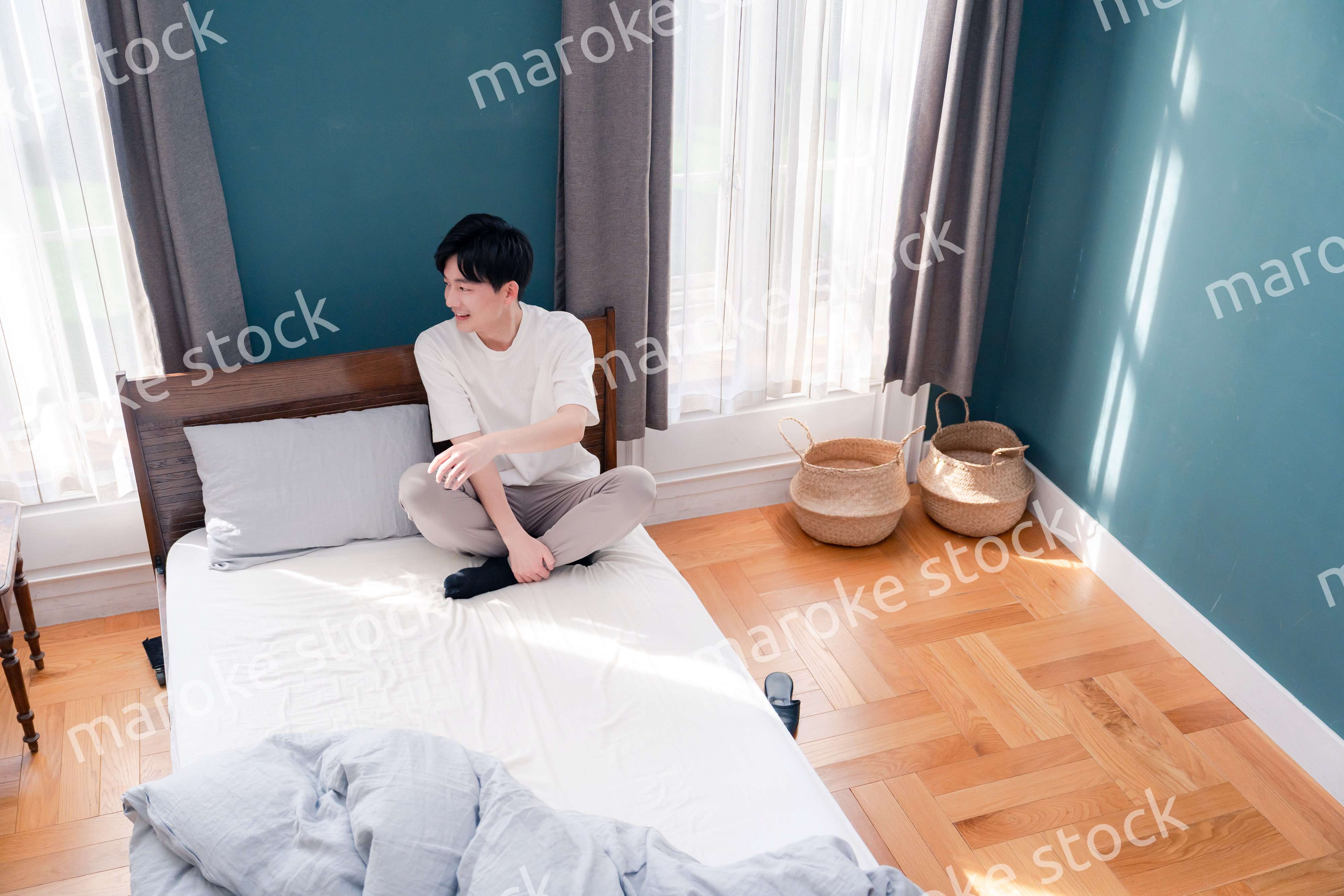 ベッドに座る若い男性