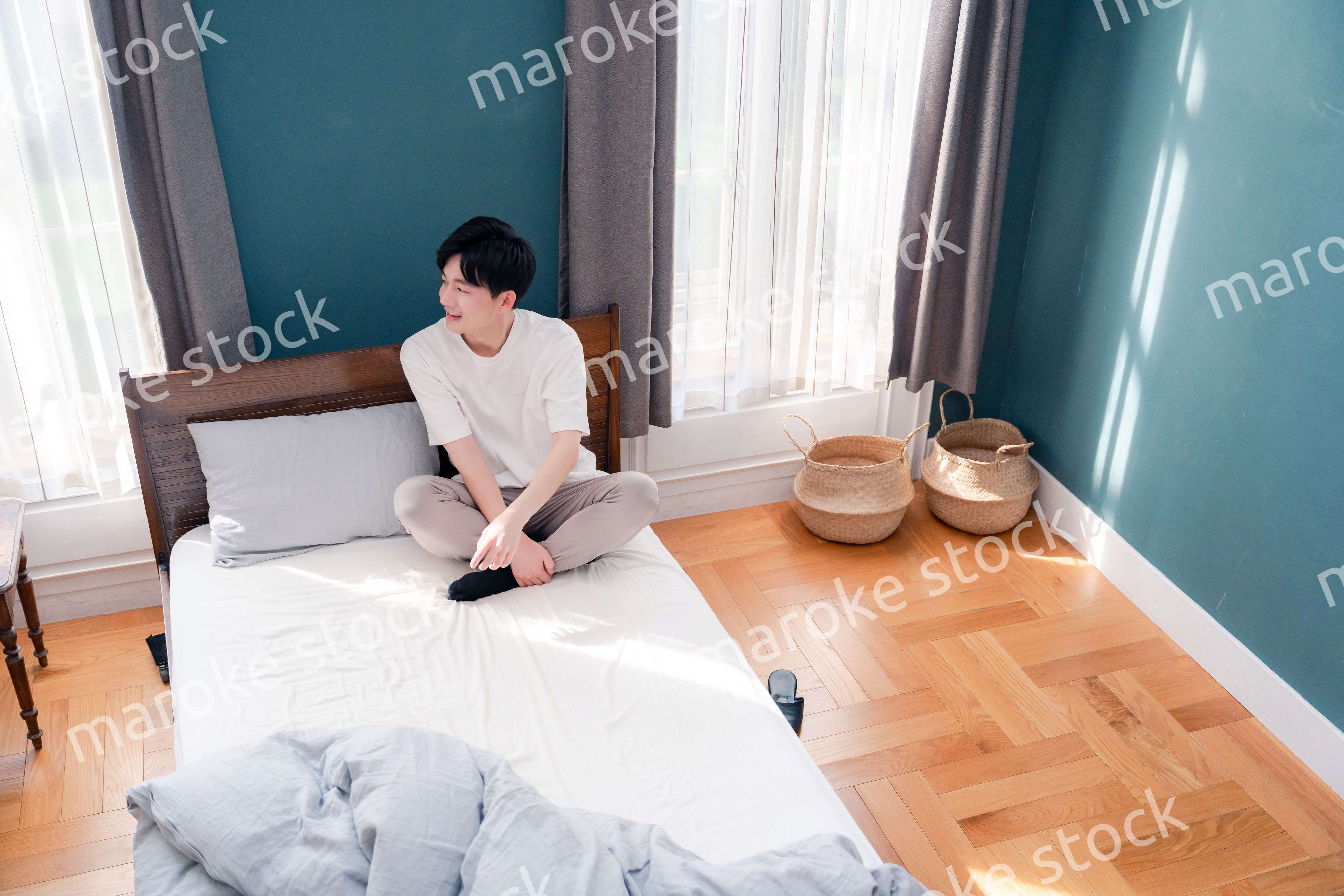 ベッドに座る若い男性